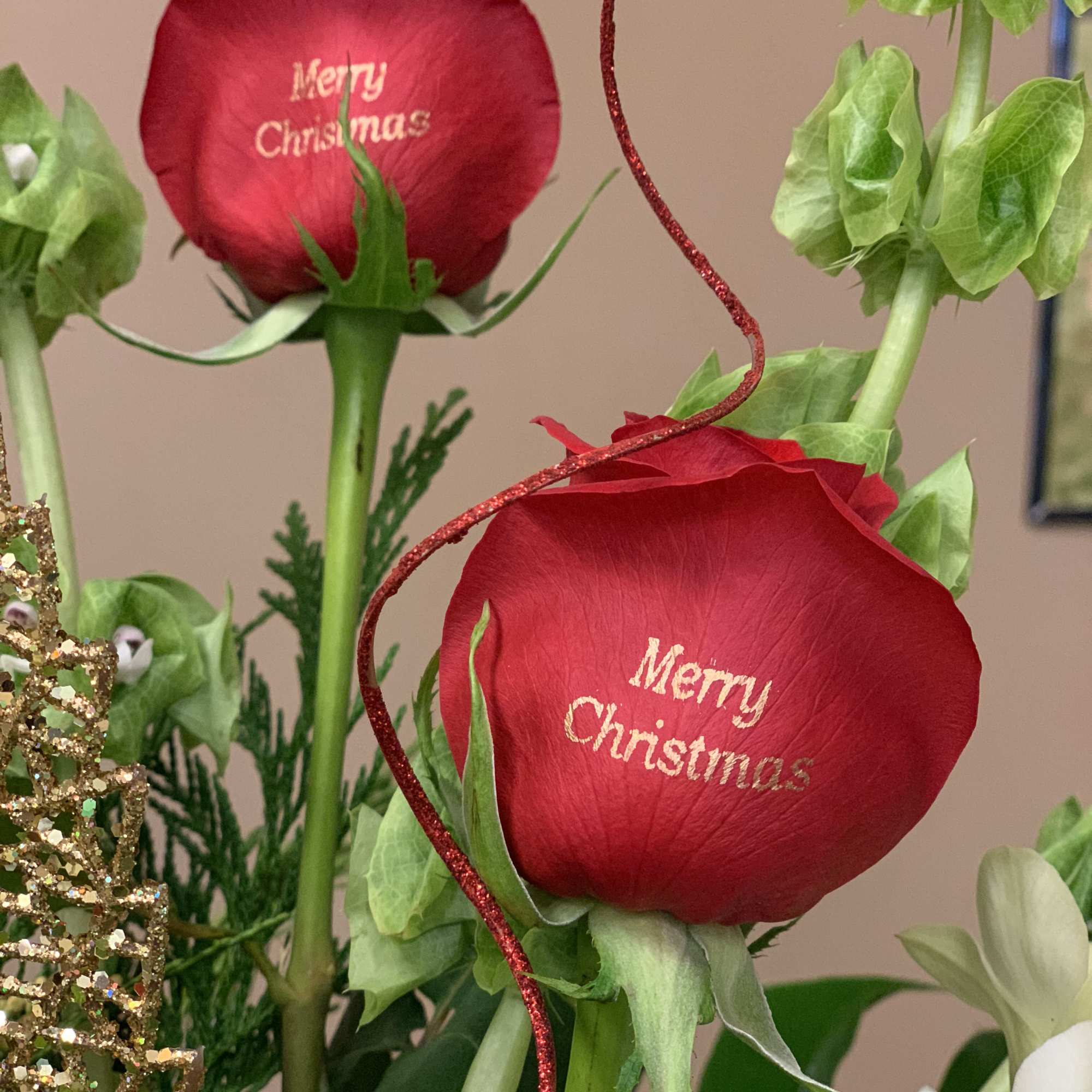 Red roses with "Merry Christmas" text and holiday decorations
