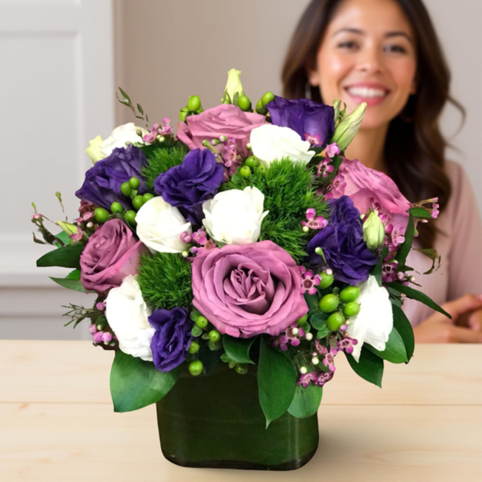 Bouquet of purple, pink, and white flowers in a dark vase