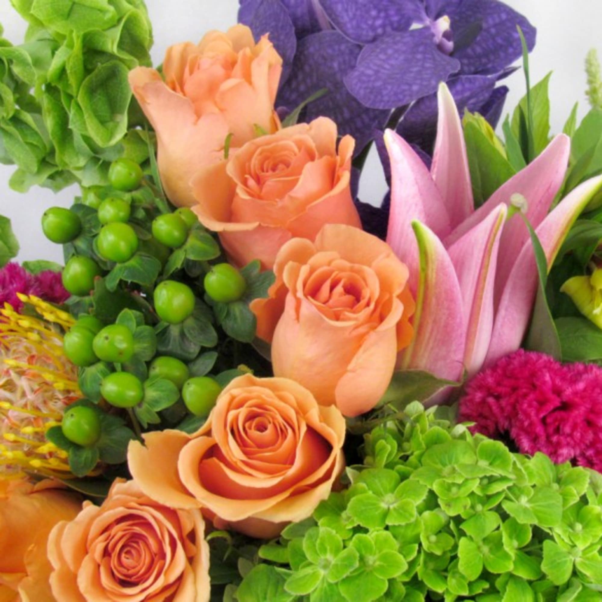 Bouquet of peach roses, pink lilies, and purple flowers