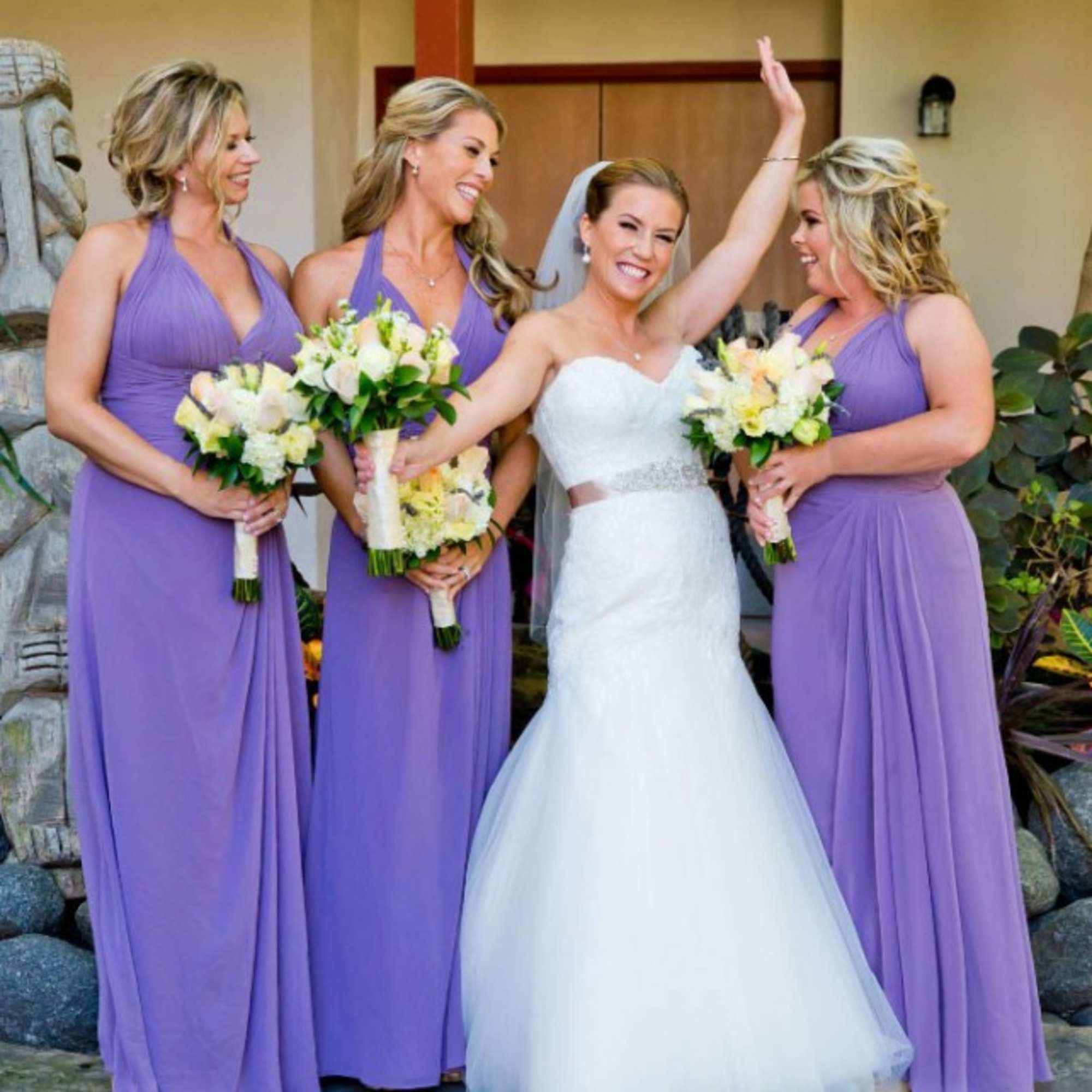 Bride with three bridesmaids holding white and pale yellow bouquets