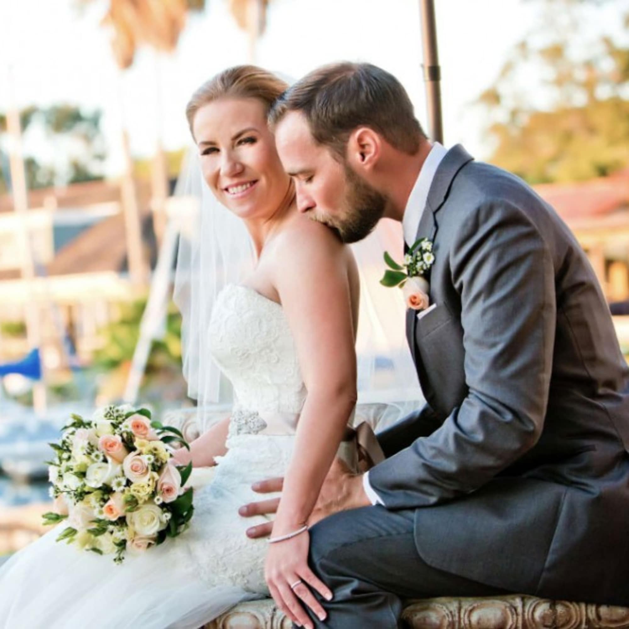 Bride holding a bouquet while seated beside a groom in a suit