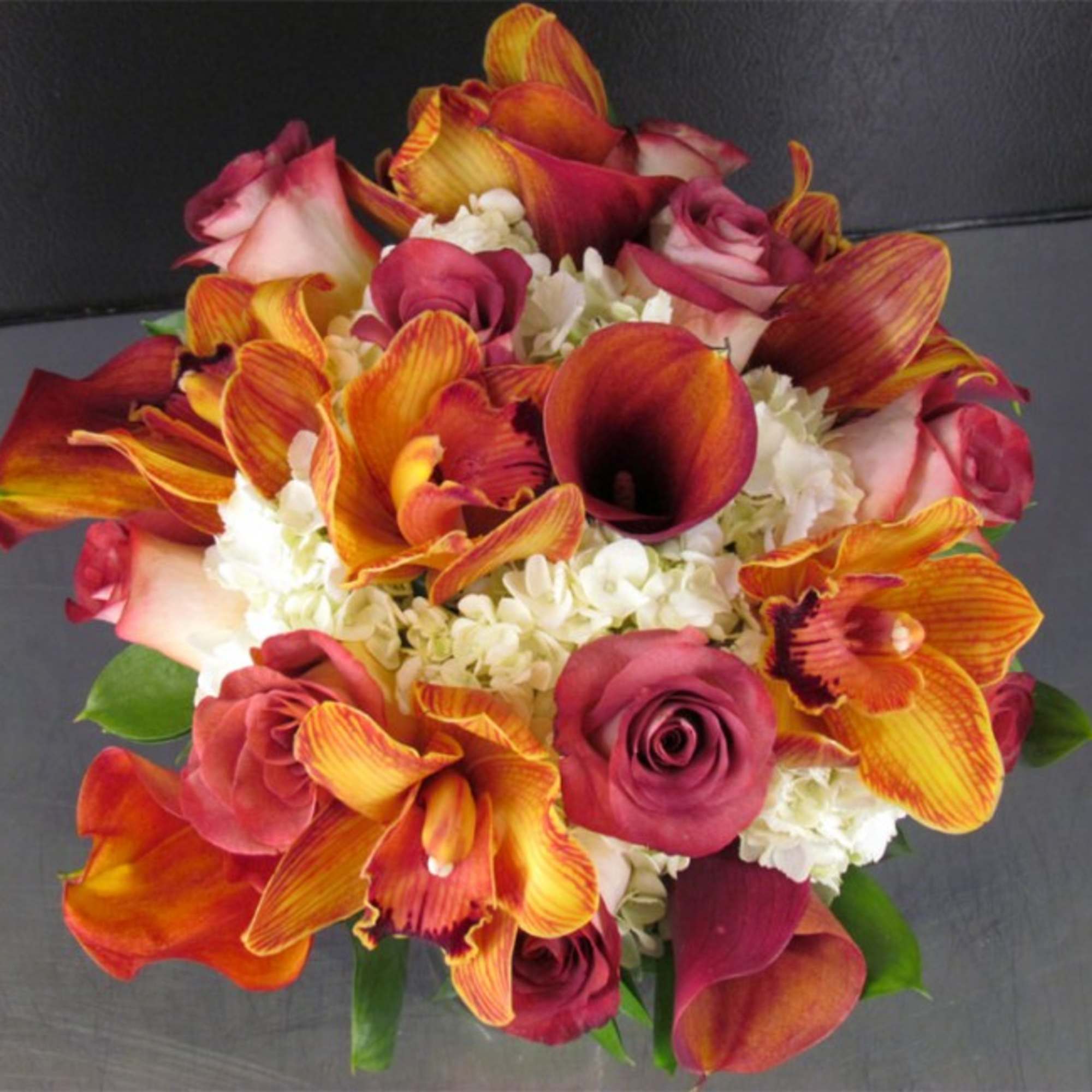 Bouquet of orange calla lilies, pink roses, and white hydrangeas