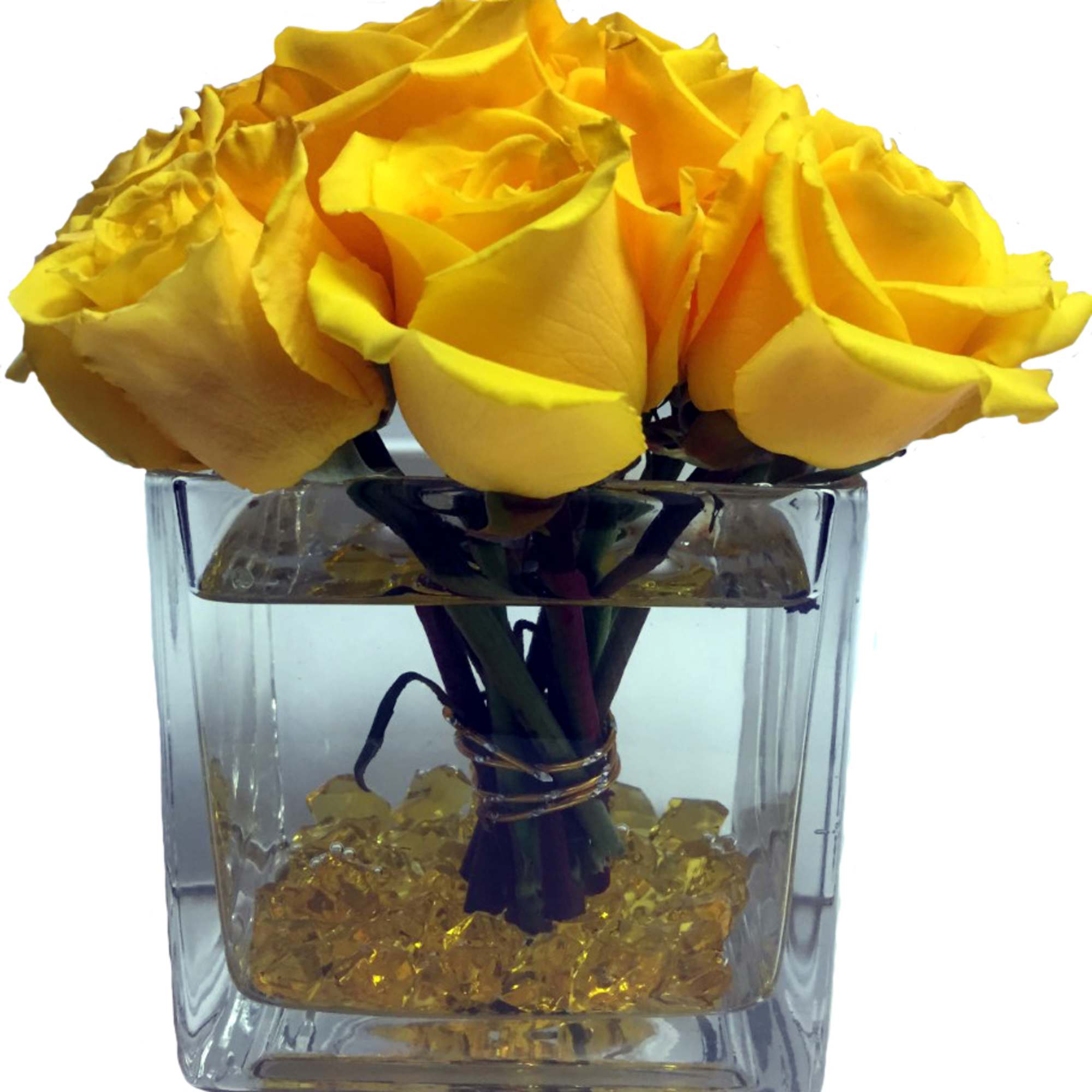 Yellow roses arranged in a clear square glass vase with gold stones