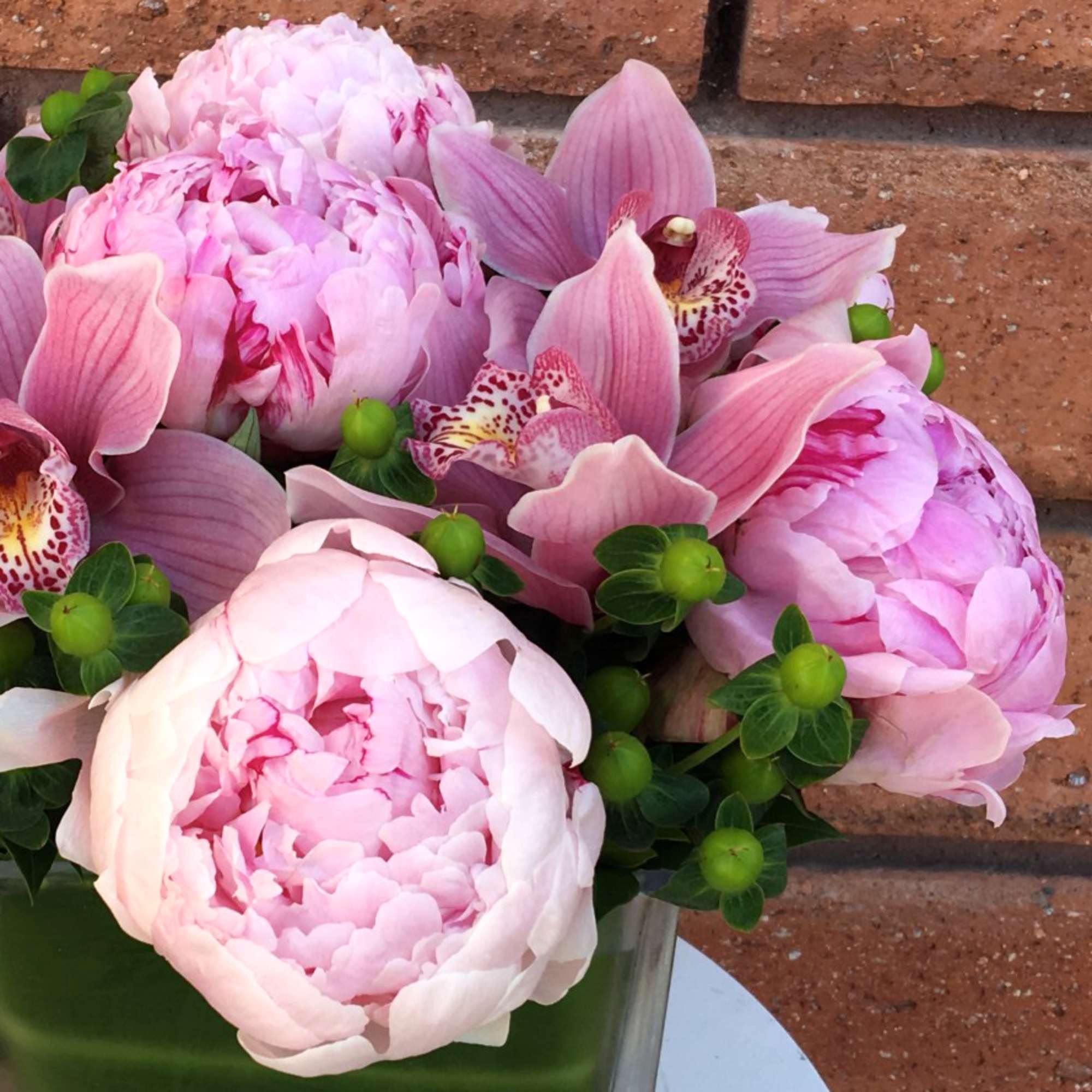 Pink peonies and orchids in a glass vase