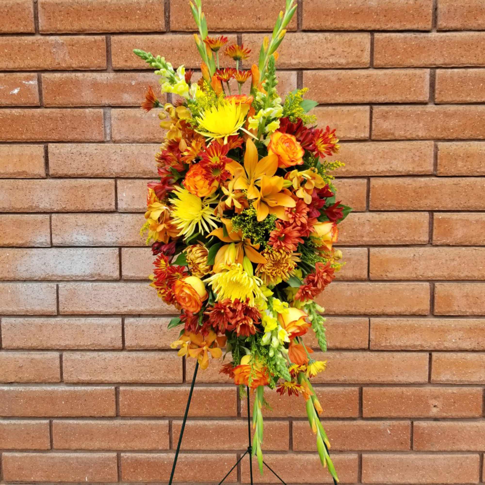 Tall autumn floral spray with yellow and orange blooms on a stand