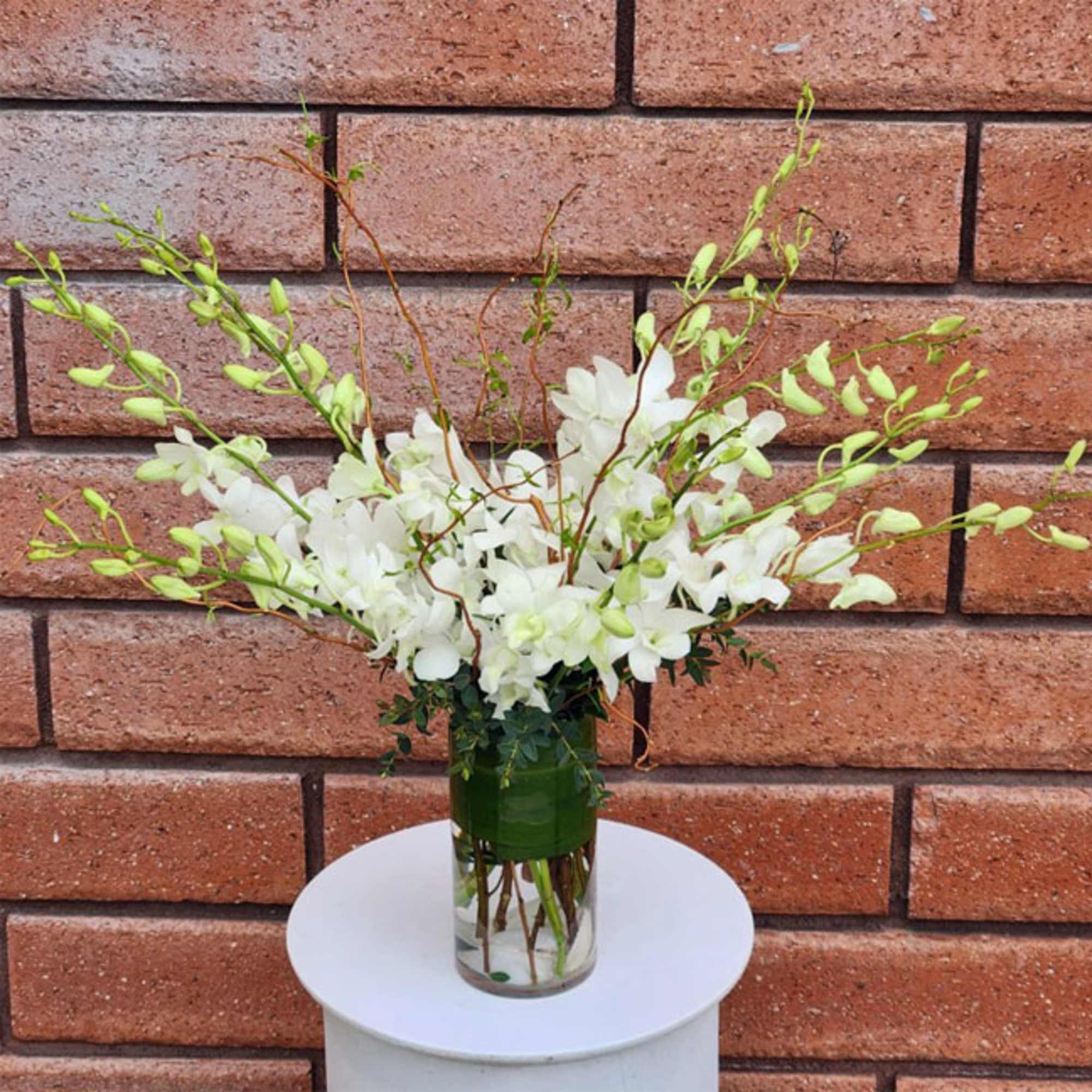 White orchid arrangement in a clear glass vase, photo 2 of 3