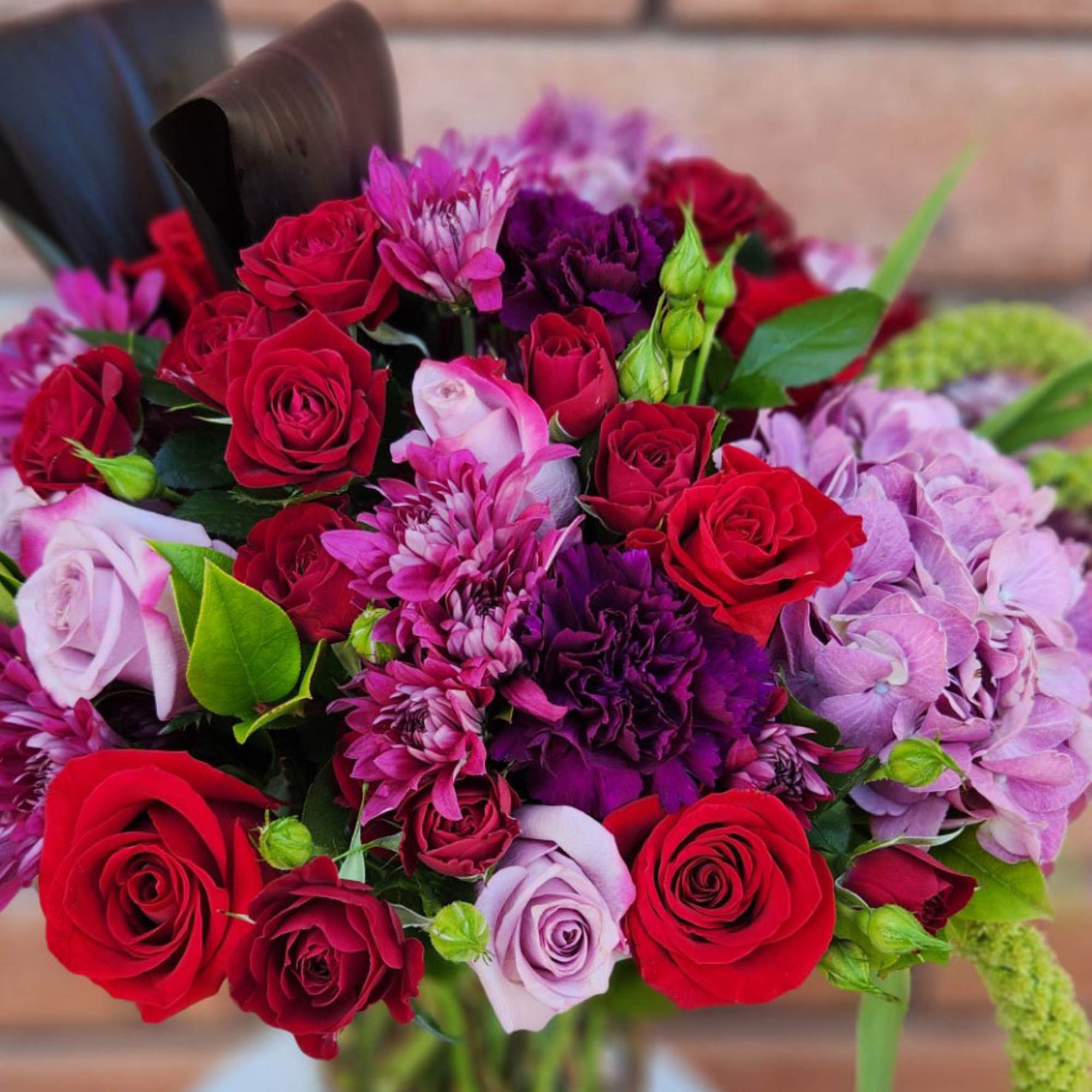 Bouquet of red and pink roses with purple flowers