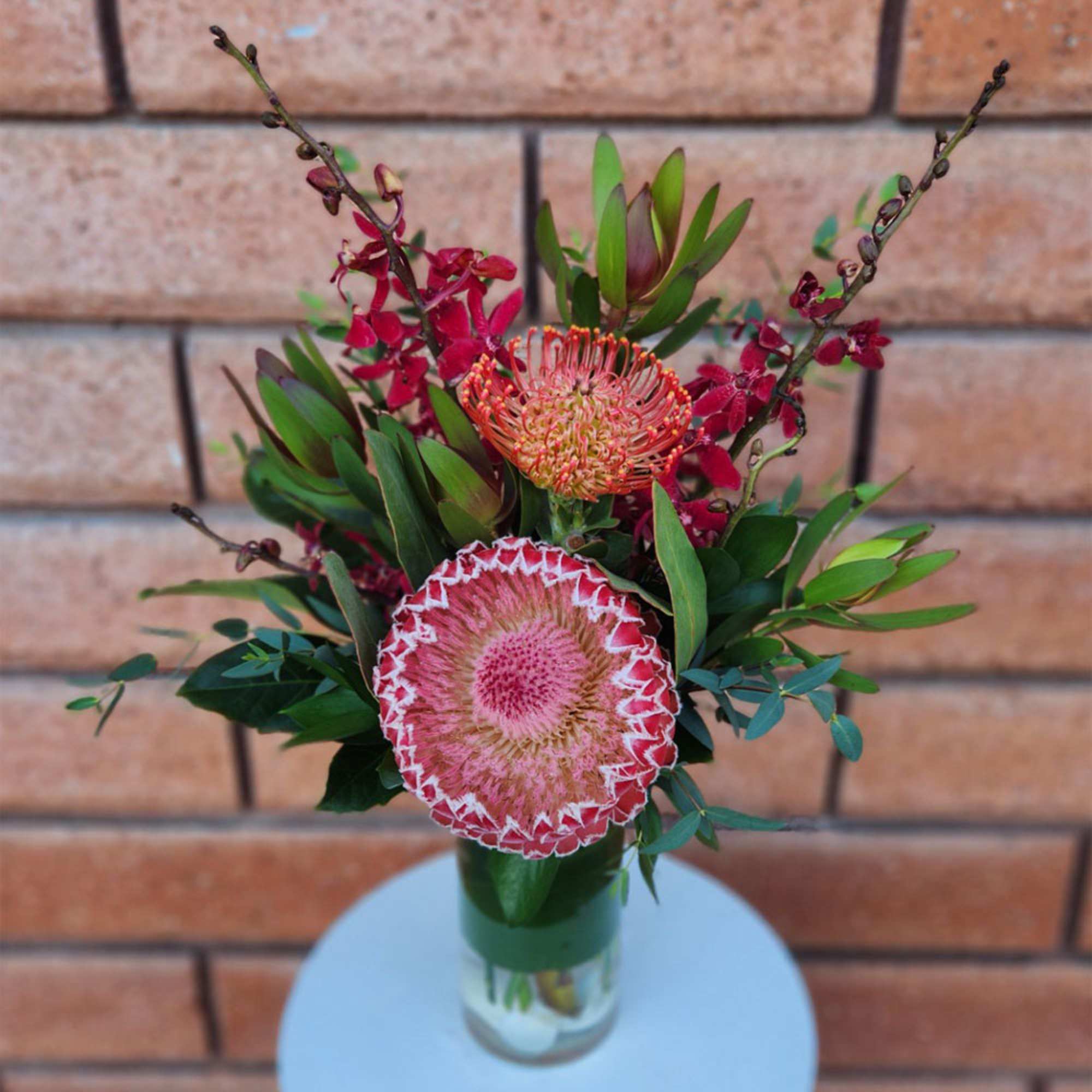 Pink protea arrangement in a glass vase