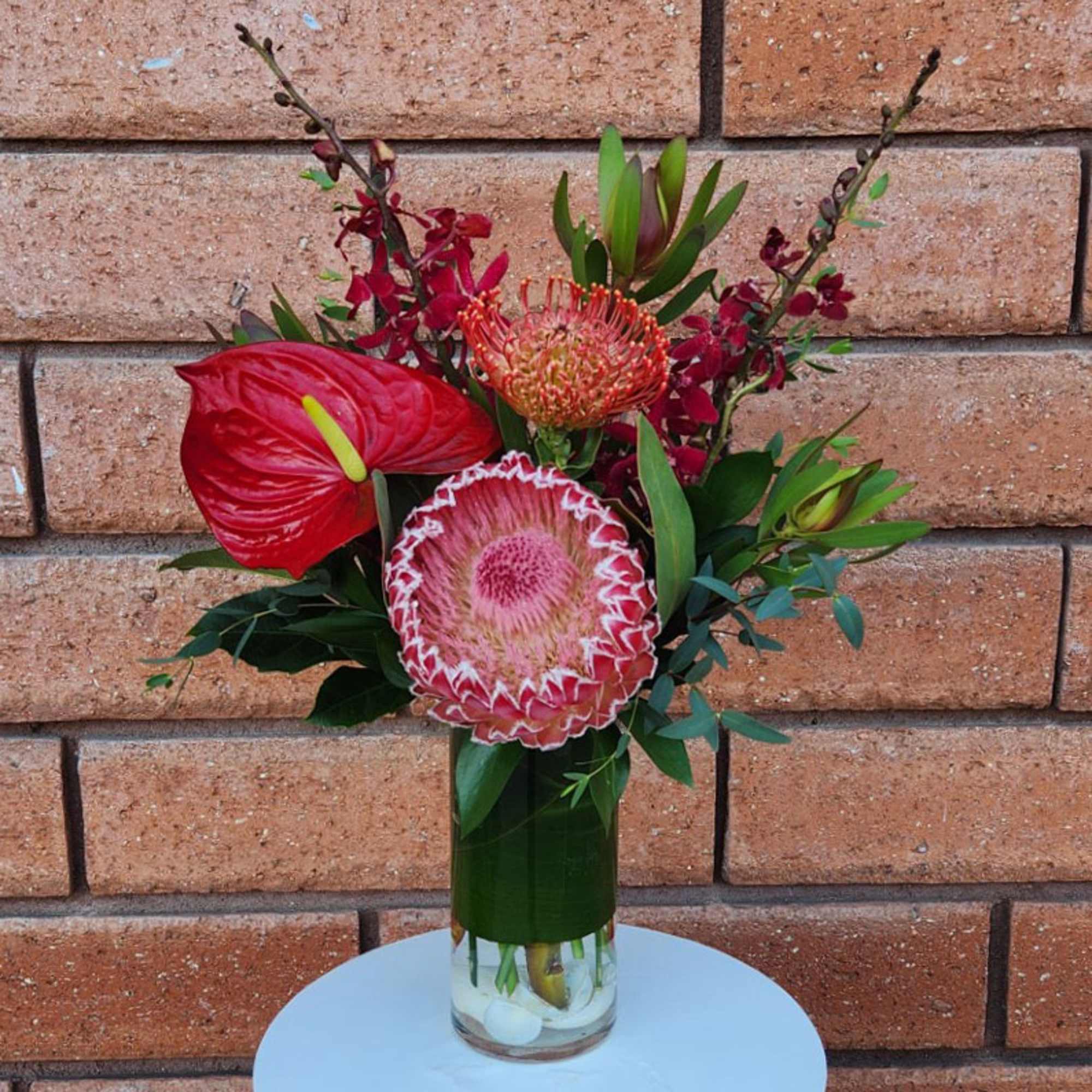 Red tropical bouquet in a clear glass vase