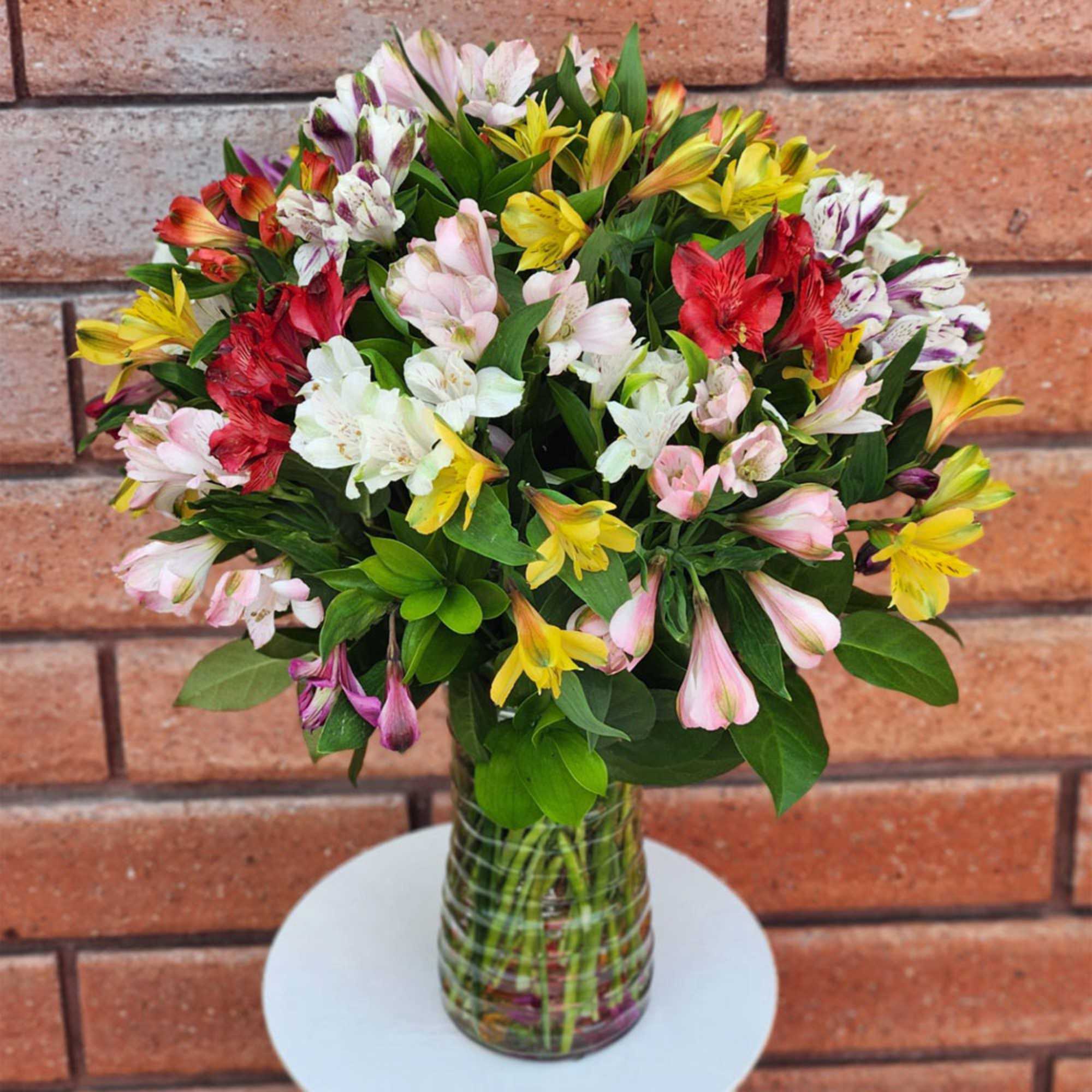 Mixed bouquet of colorful alstroemeria in a glass vase