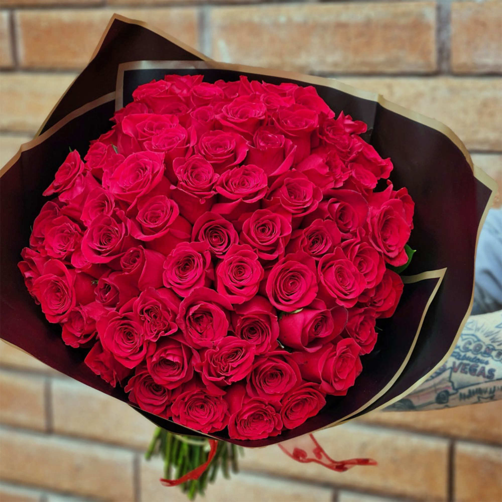 Bouquet of red roses wrapped in dark paper