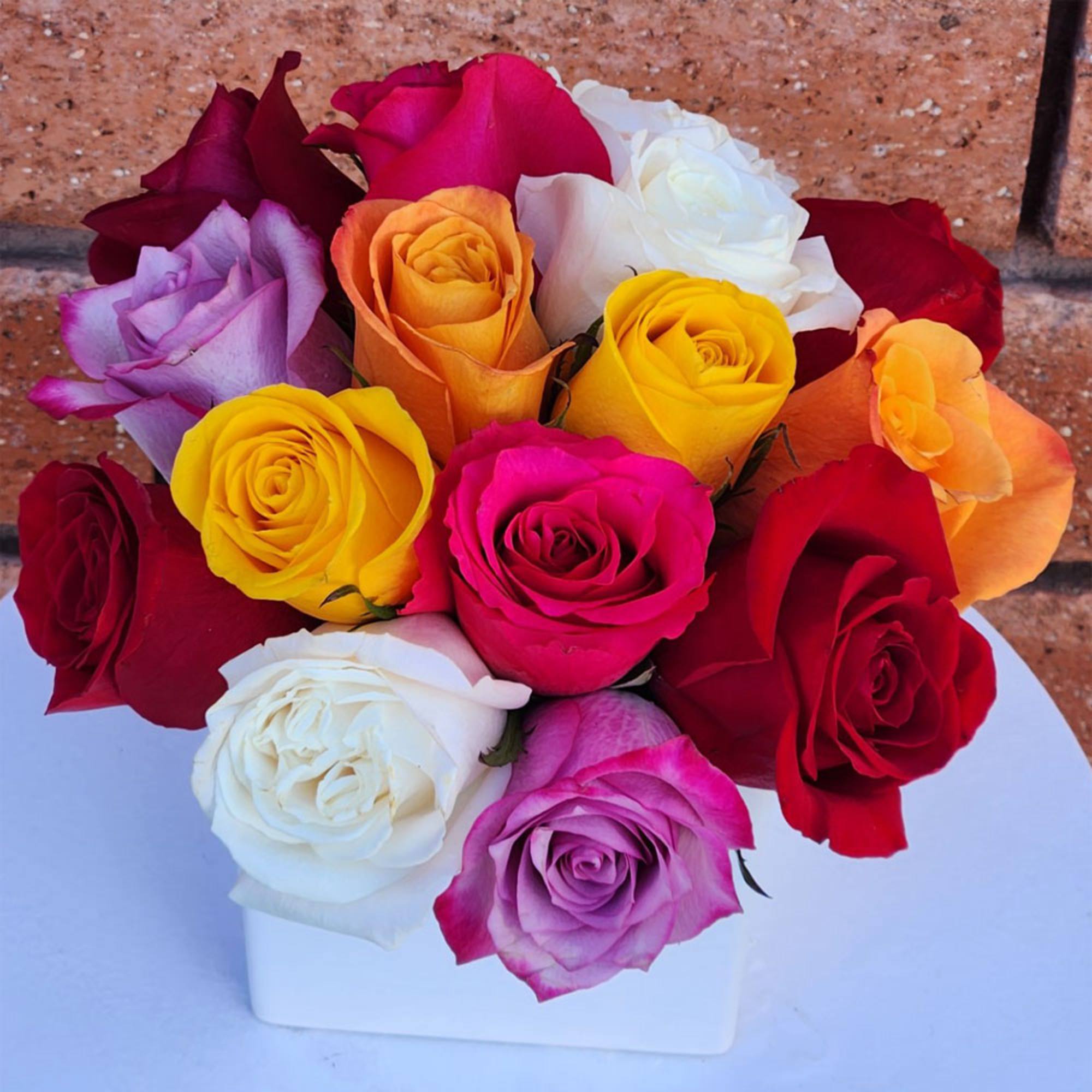 Colorful roses arranged in a white rectangular vase