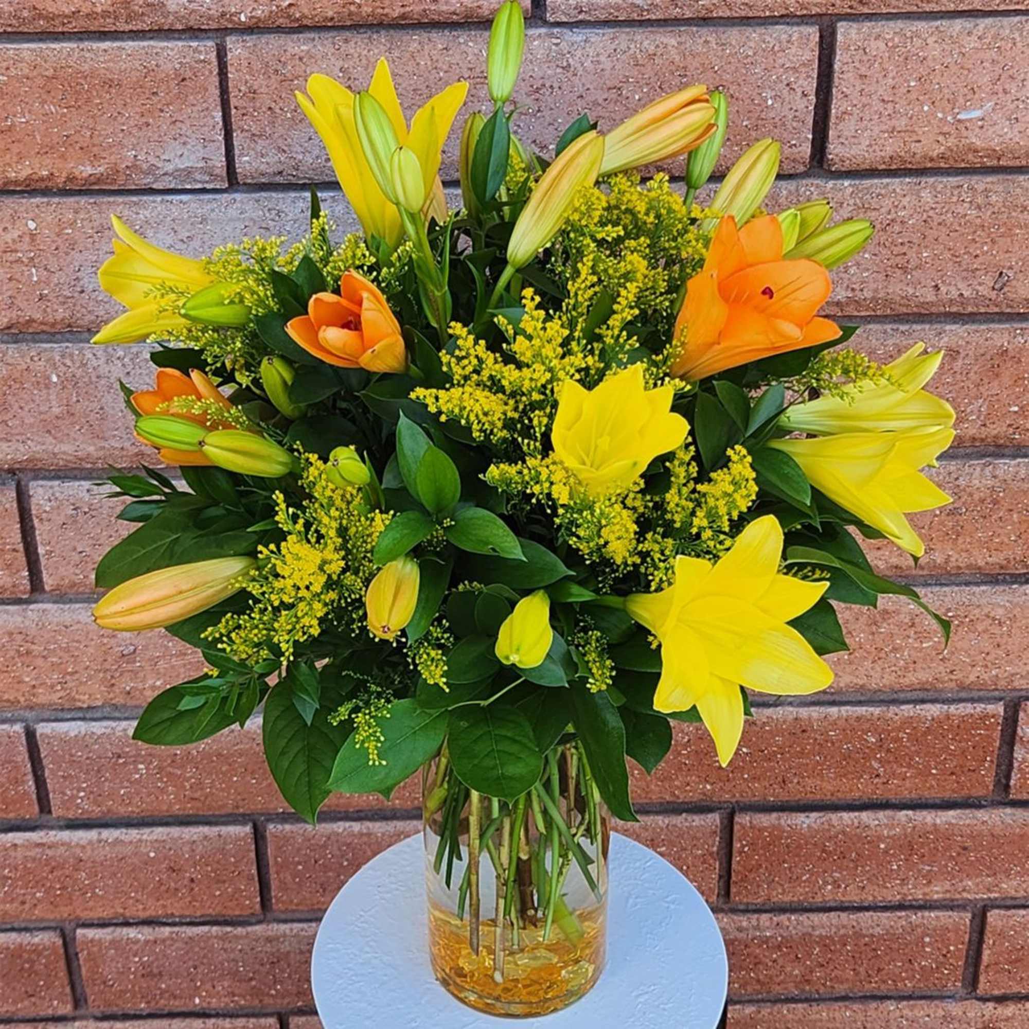 Yellow and orange lily bouquet in a clear glass vase