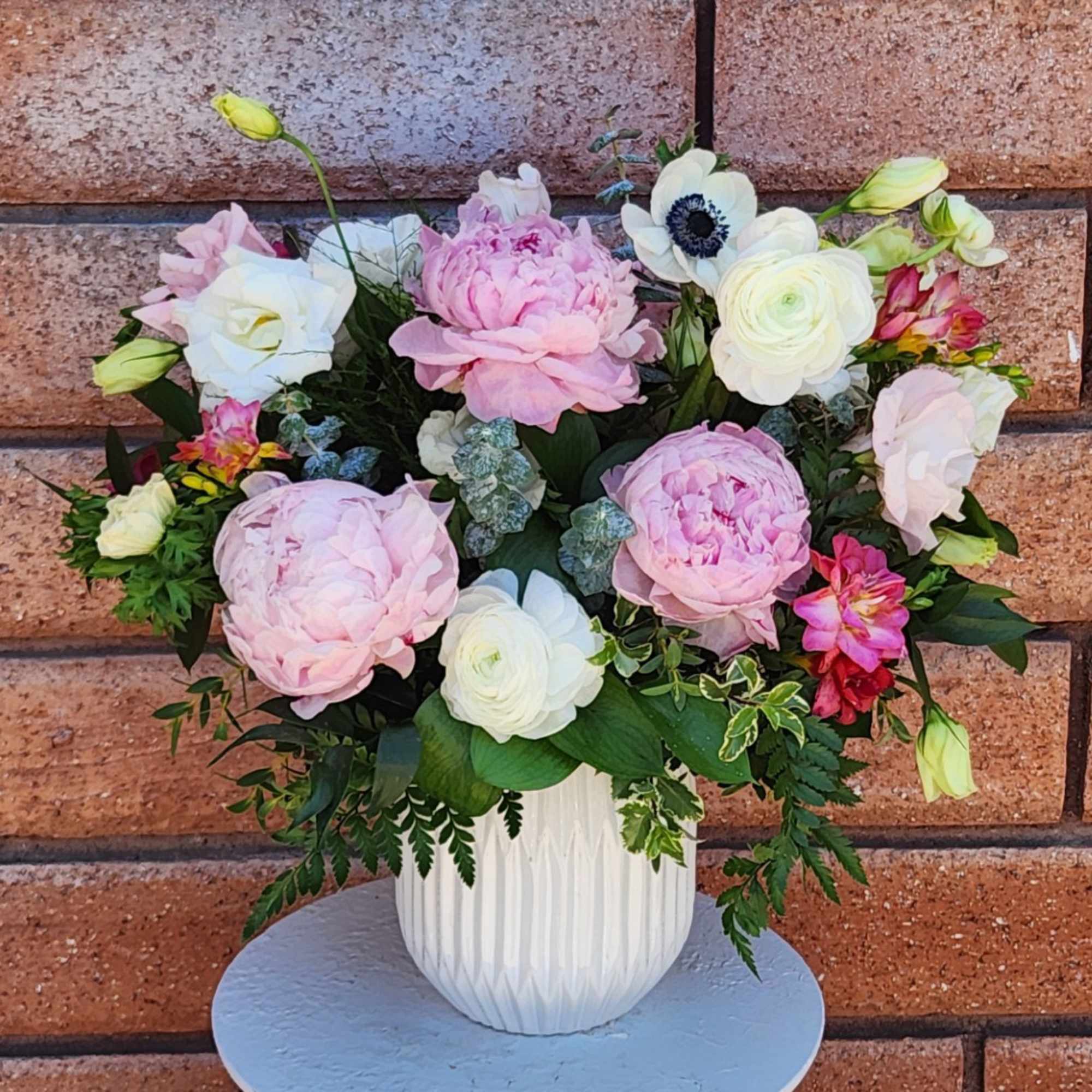 Pink and white floral arrangement in a white vase