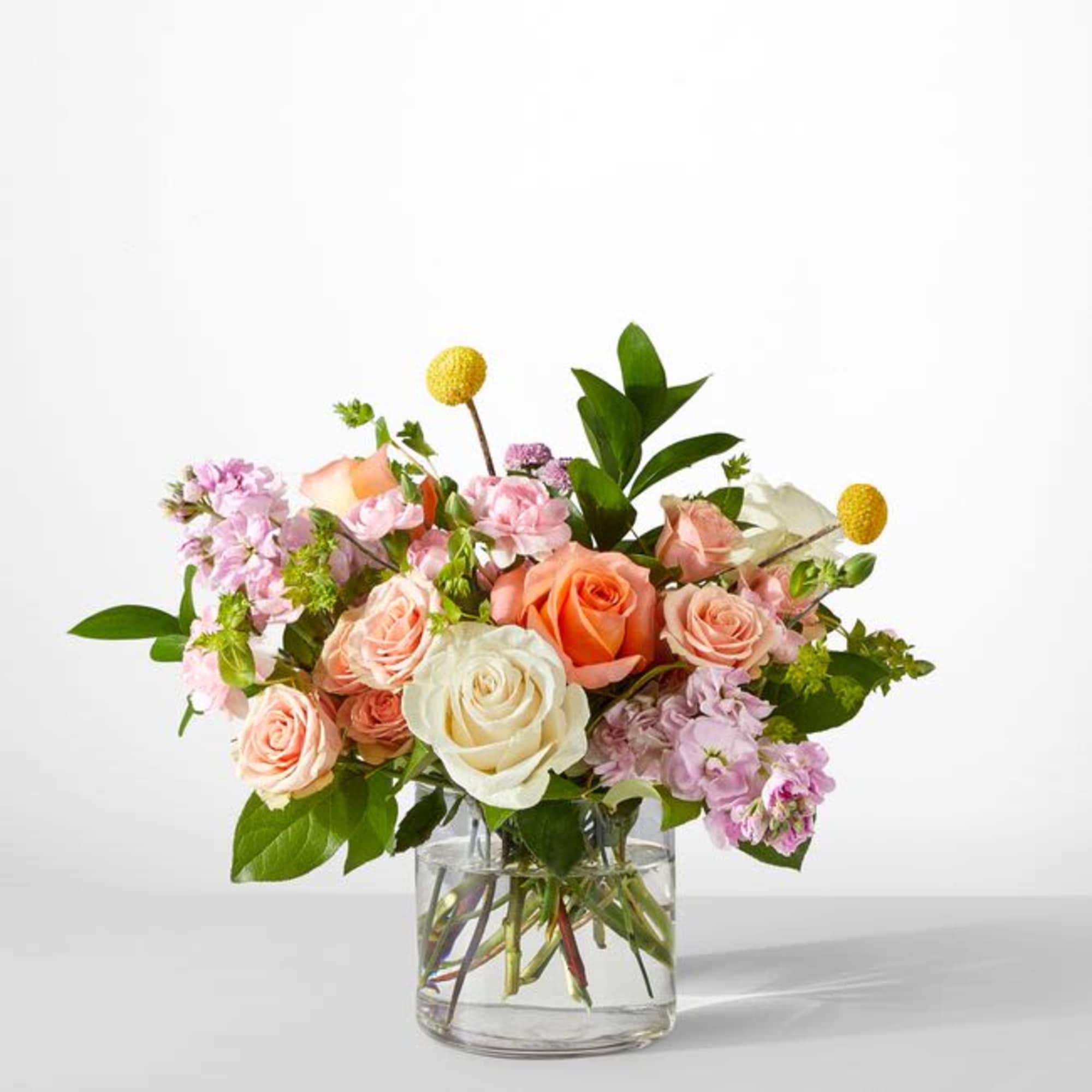 Bouquet of pink and peach roses in a clear glass vase