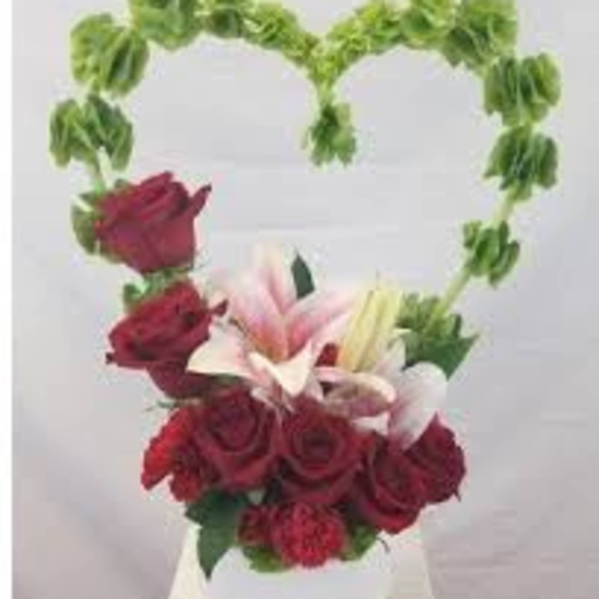 Heart-shaped floral arrangement with red roses and lilies