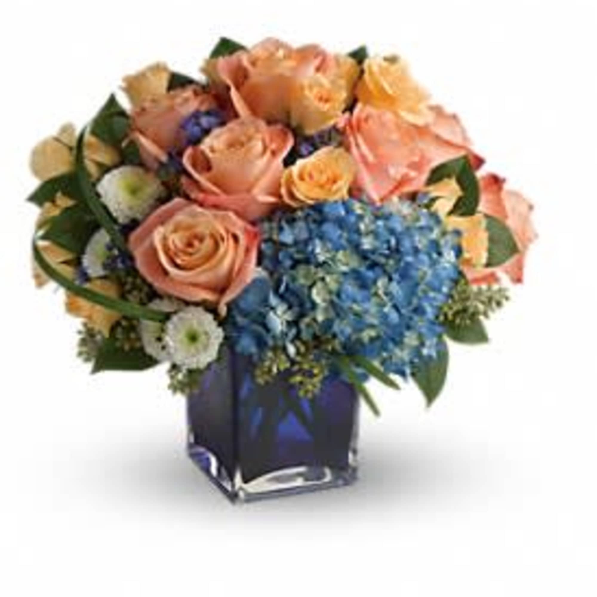 Peach roses and blue hydrangeas in a square glass vase