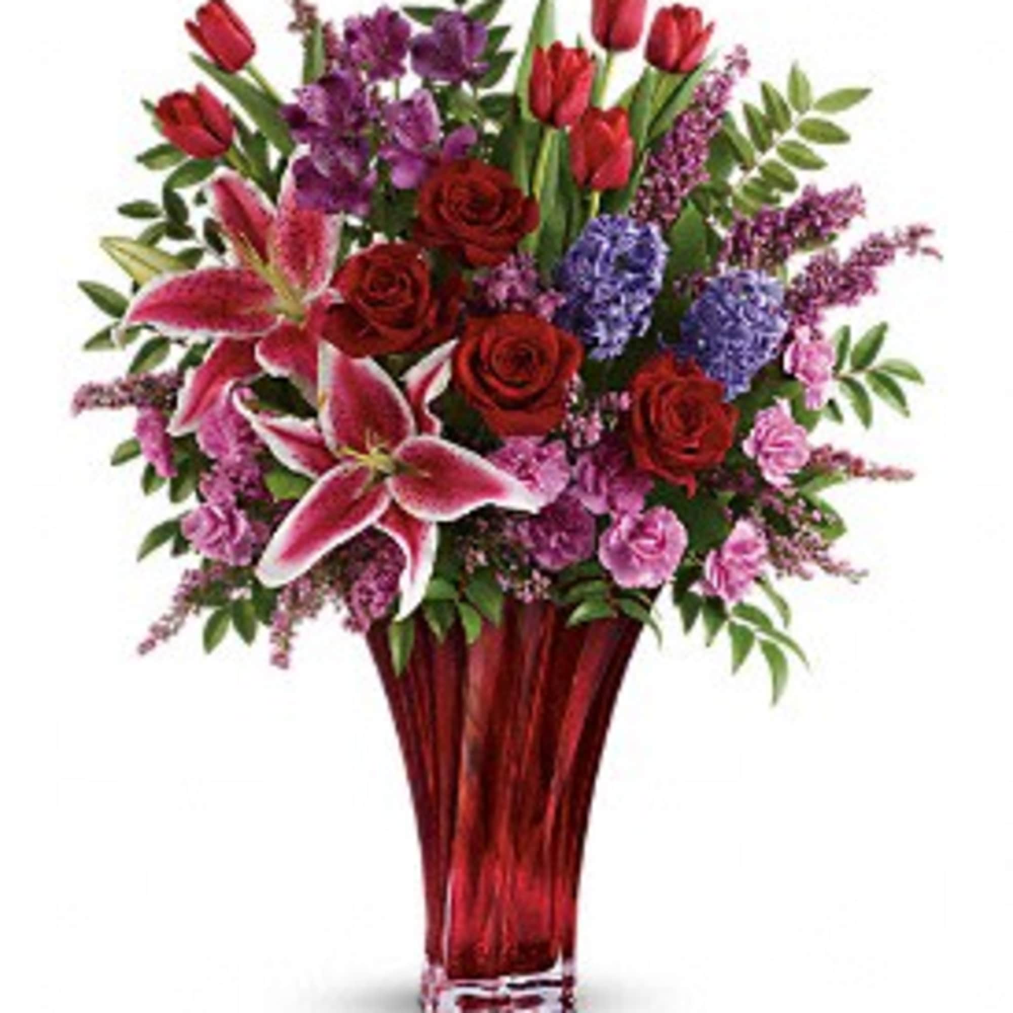 Mixed bouquet of red roses, pink lilies, and purple flowers in a red vase