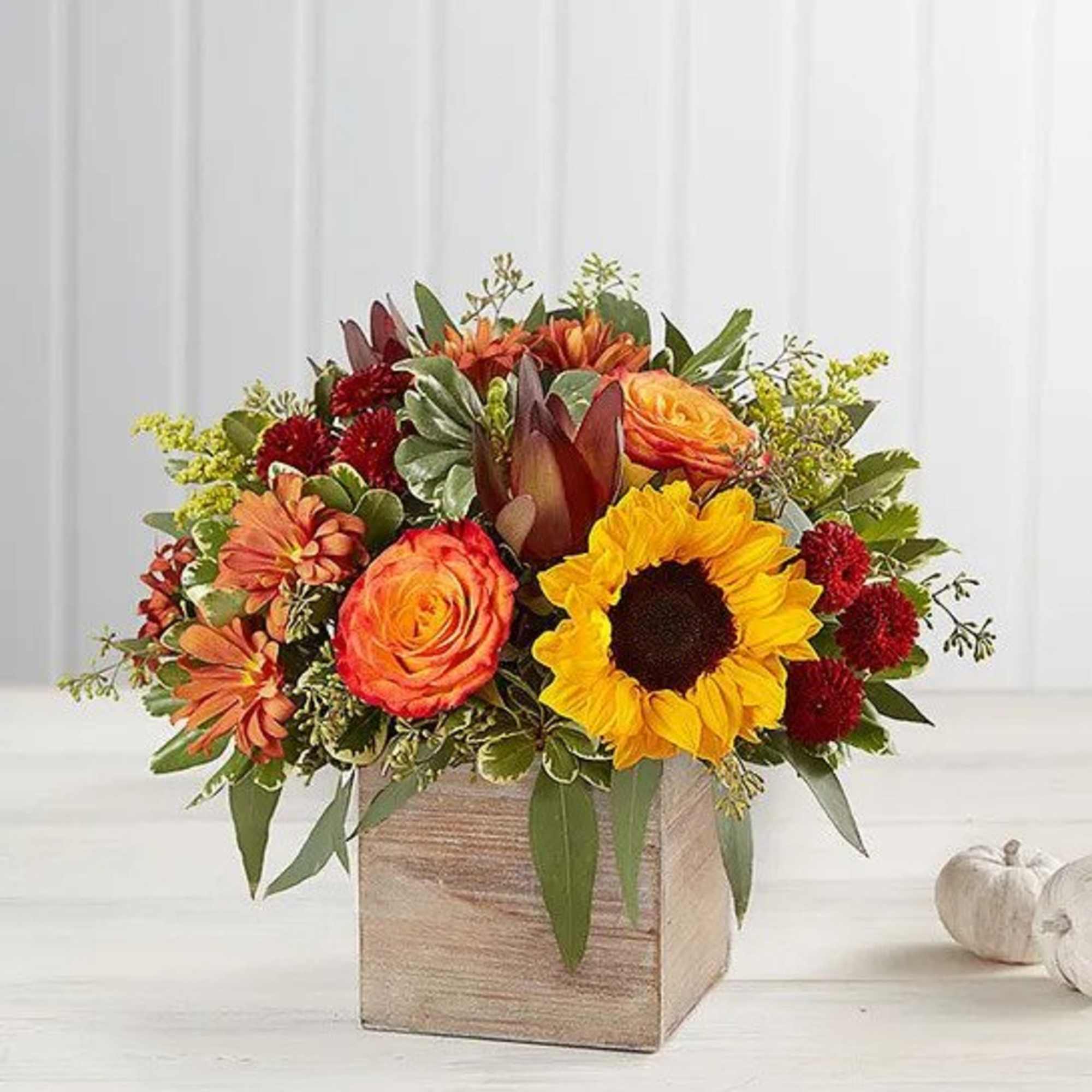 Autumn floral arrangement with sunflowers, roses, and mums in a wooden box