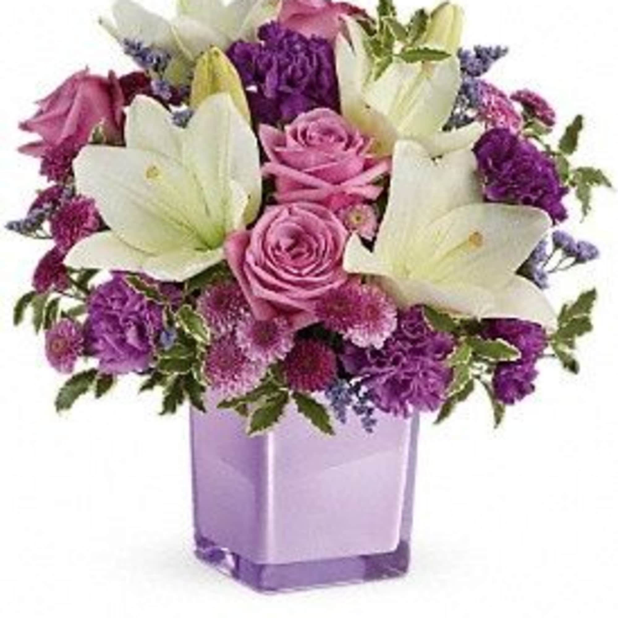 Pink roses and white lilies in a purple glass vase