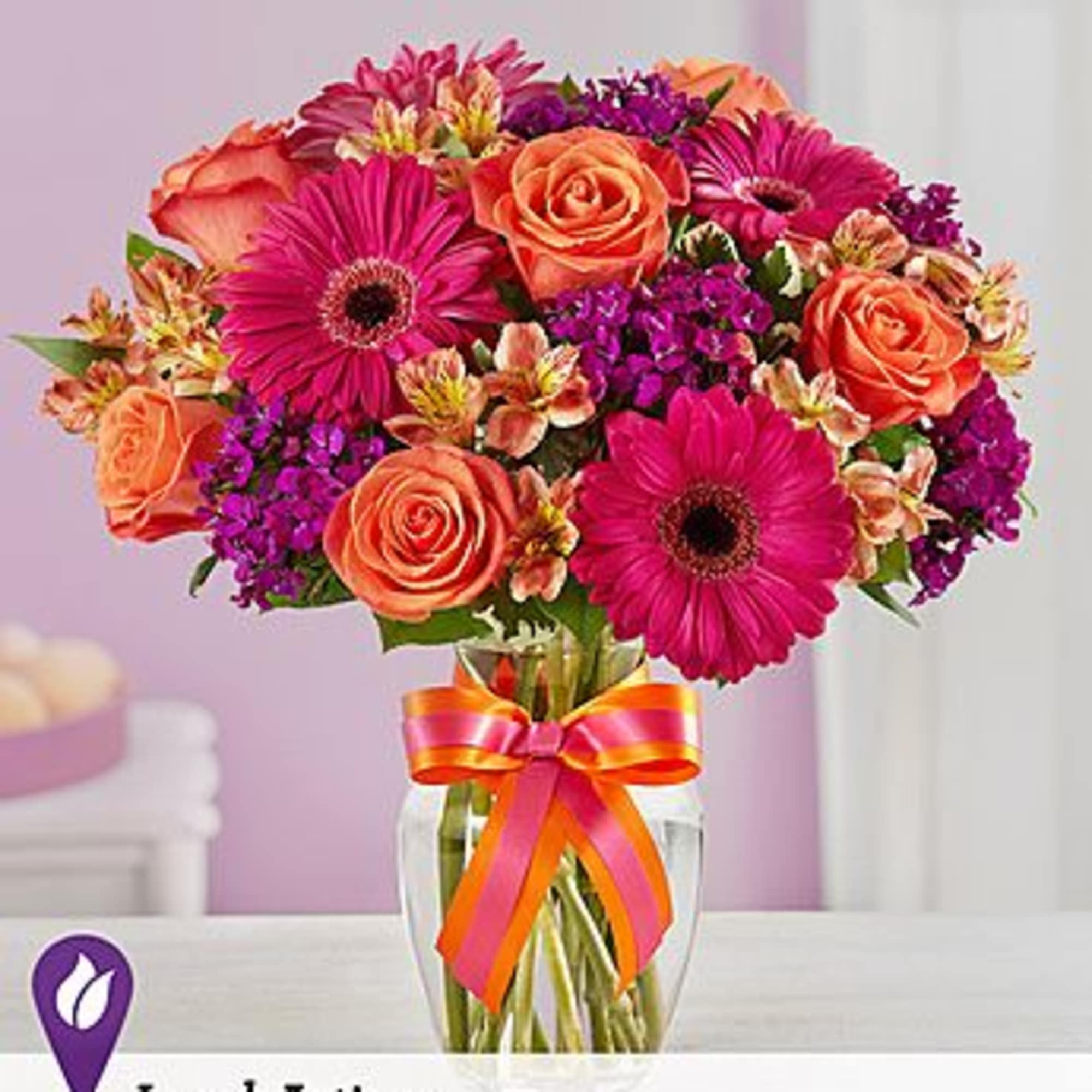 Bouquet of pink gerbera daisies and orange roses in a glass vase