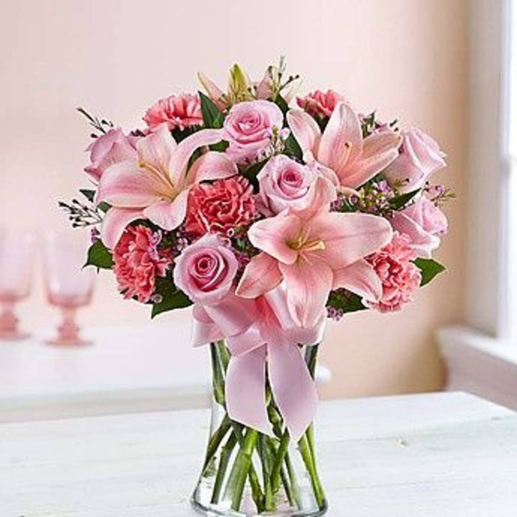 Filled with a delicate mix of roses, lilies and carnations in various