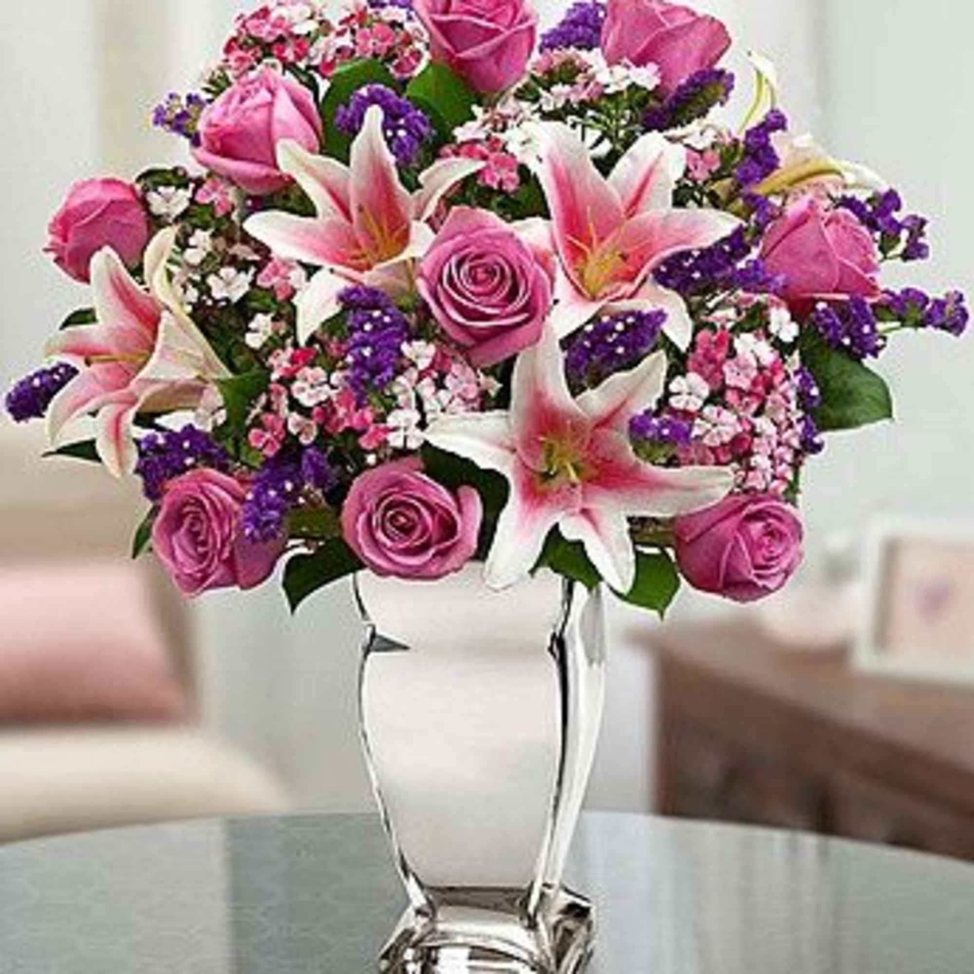 Pink roses and lilies arranged in a white vase