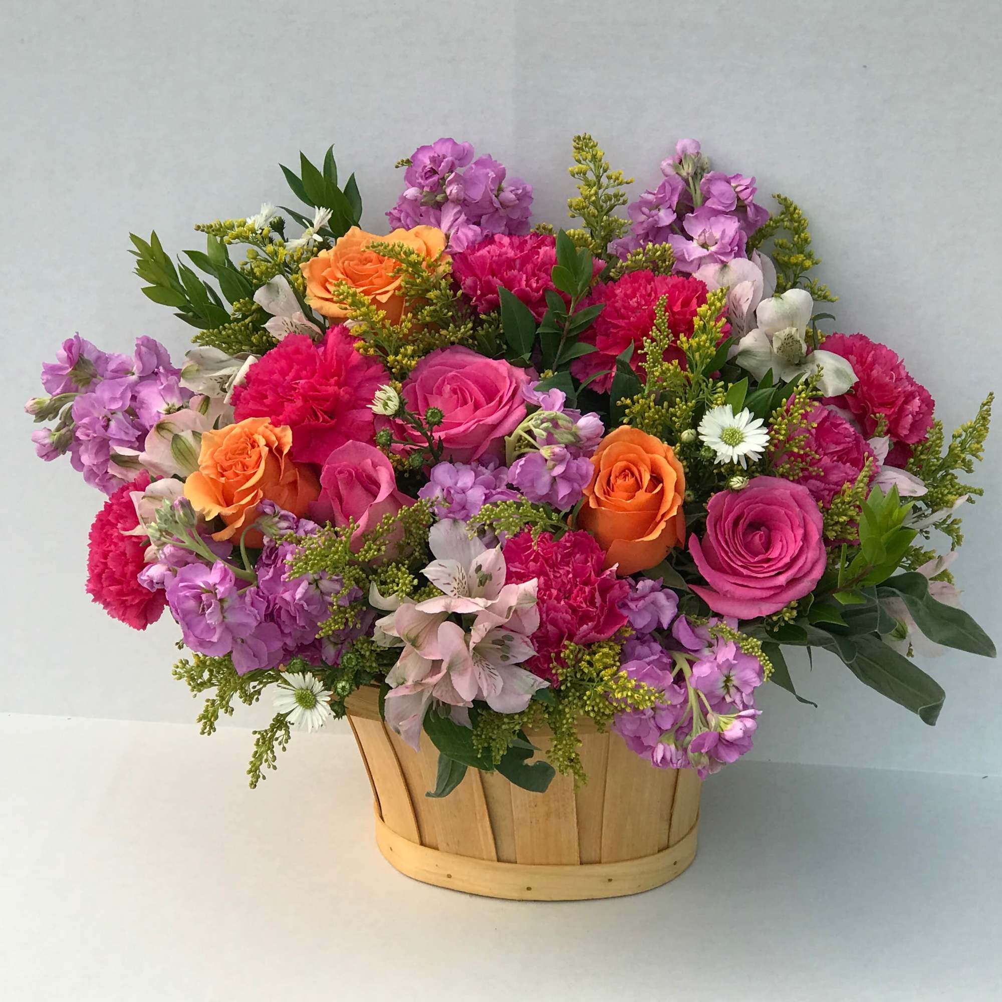 Mixed bouquet of pink, purple, and orange flowers in a wooden basket, photo 2 of 2