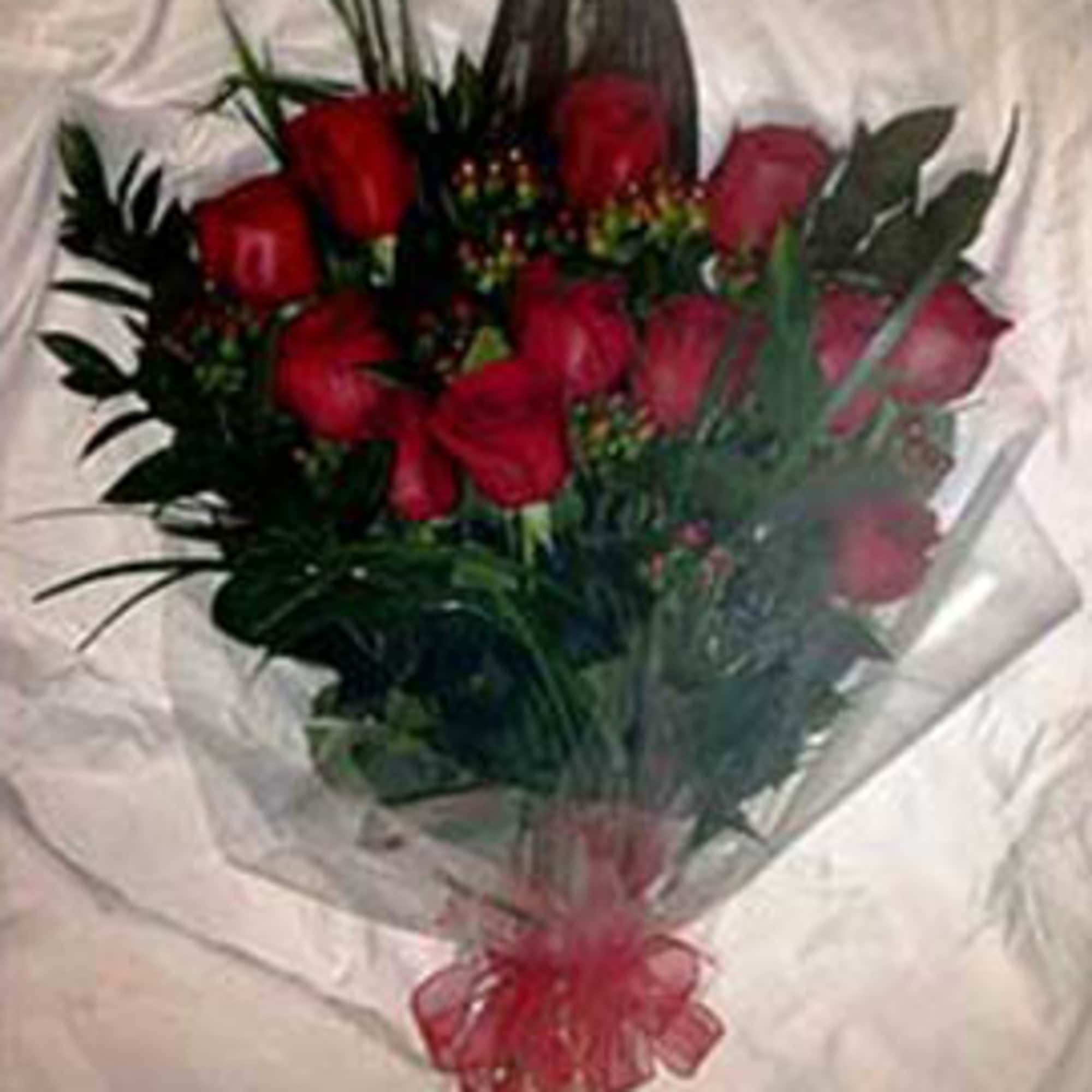 Hand-tied bouquet of red roses wrapped in clear cellophane with a red bow