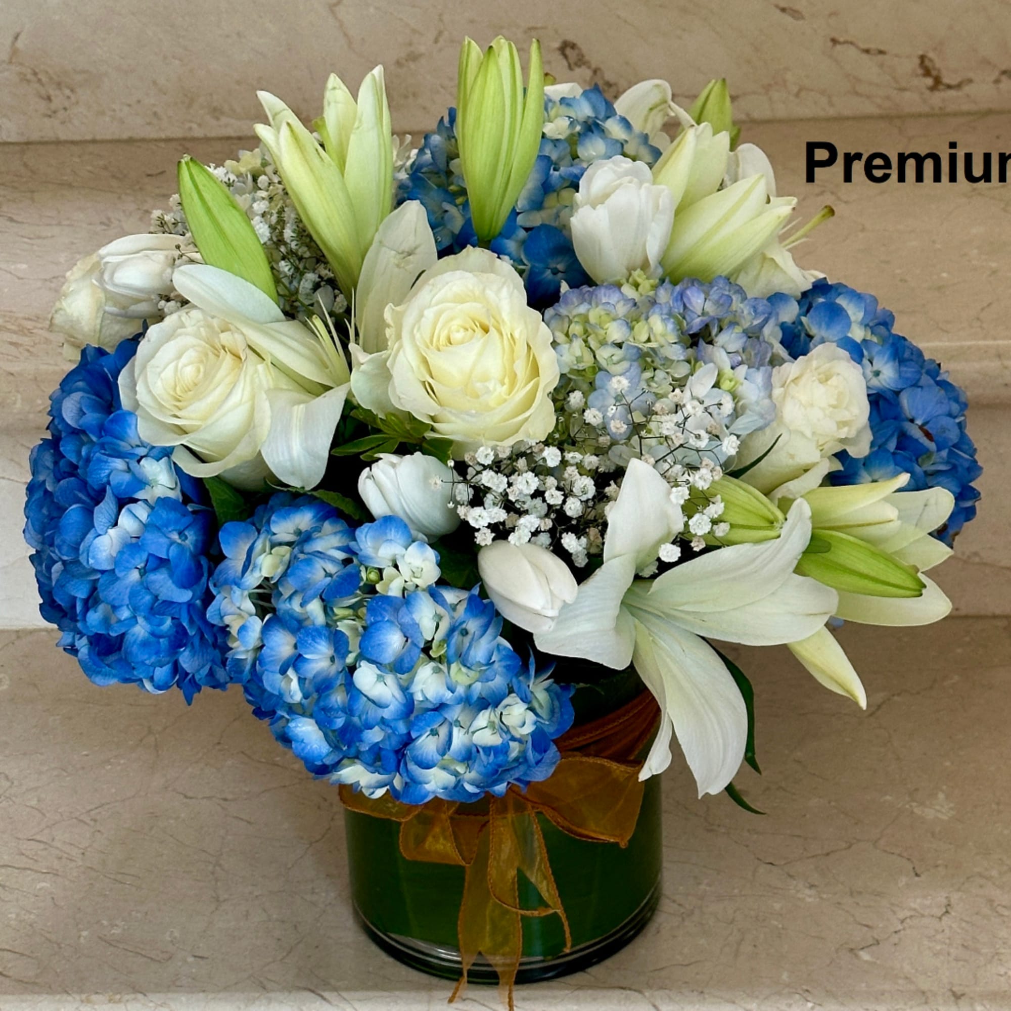 White roses and lilies with blue hydrangeas in a green vase