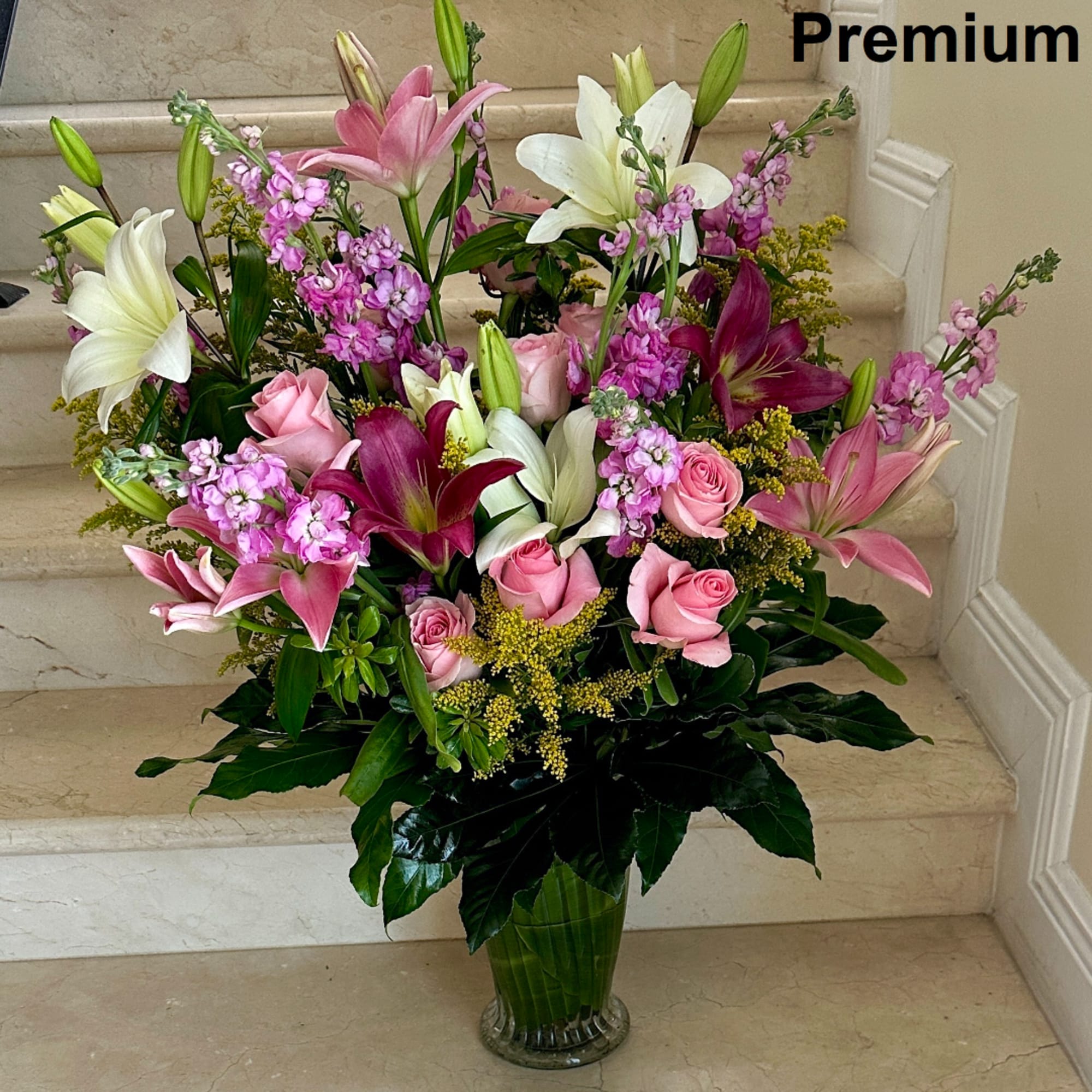 Pink and white lilies with roses in a glass vase