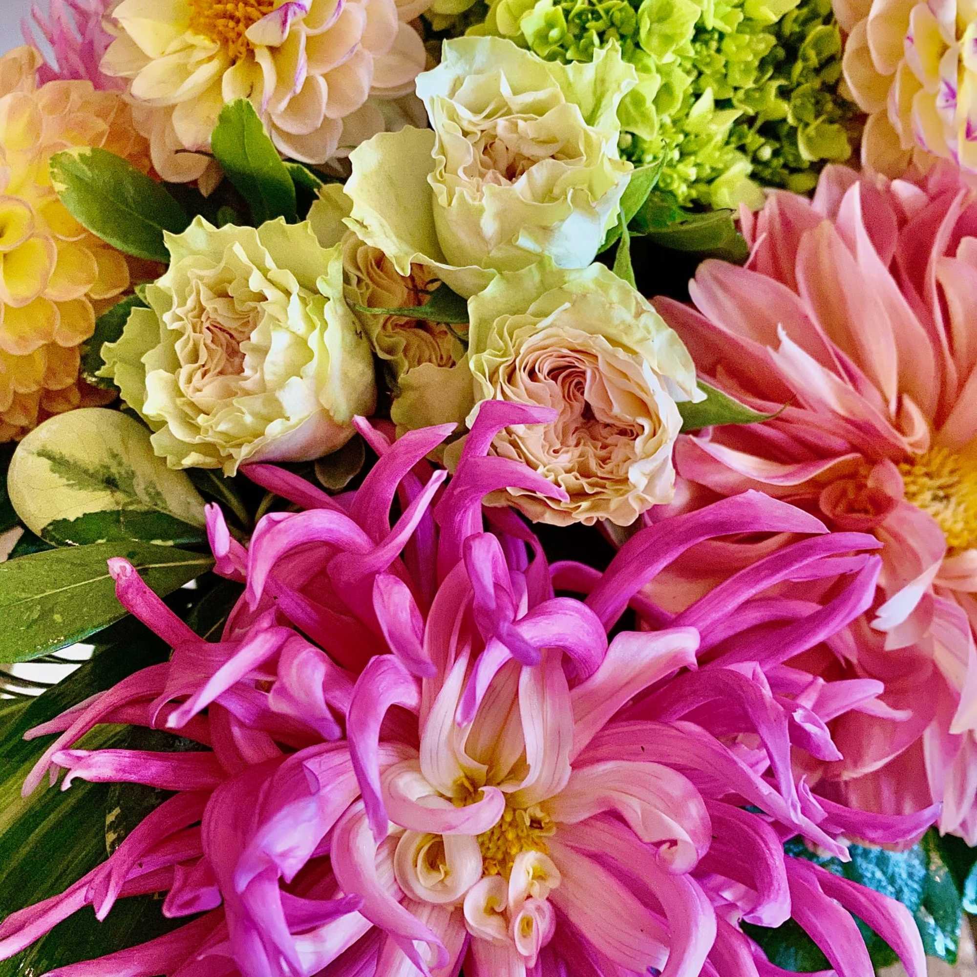 Colorful bouquet with pink and cream flowers and bright green blooms