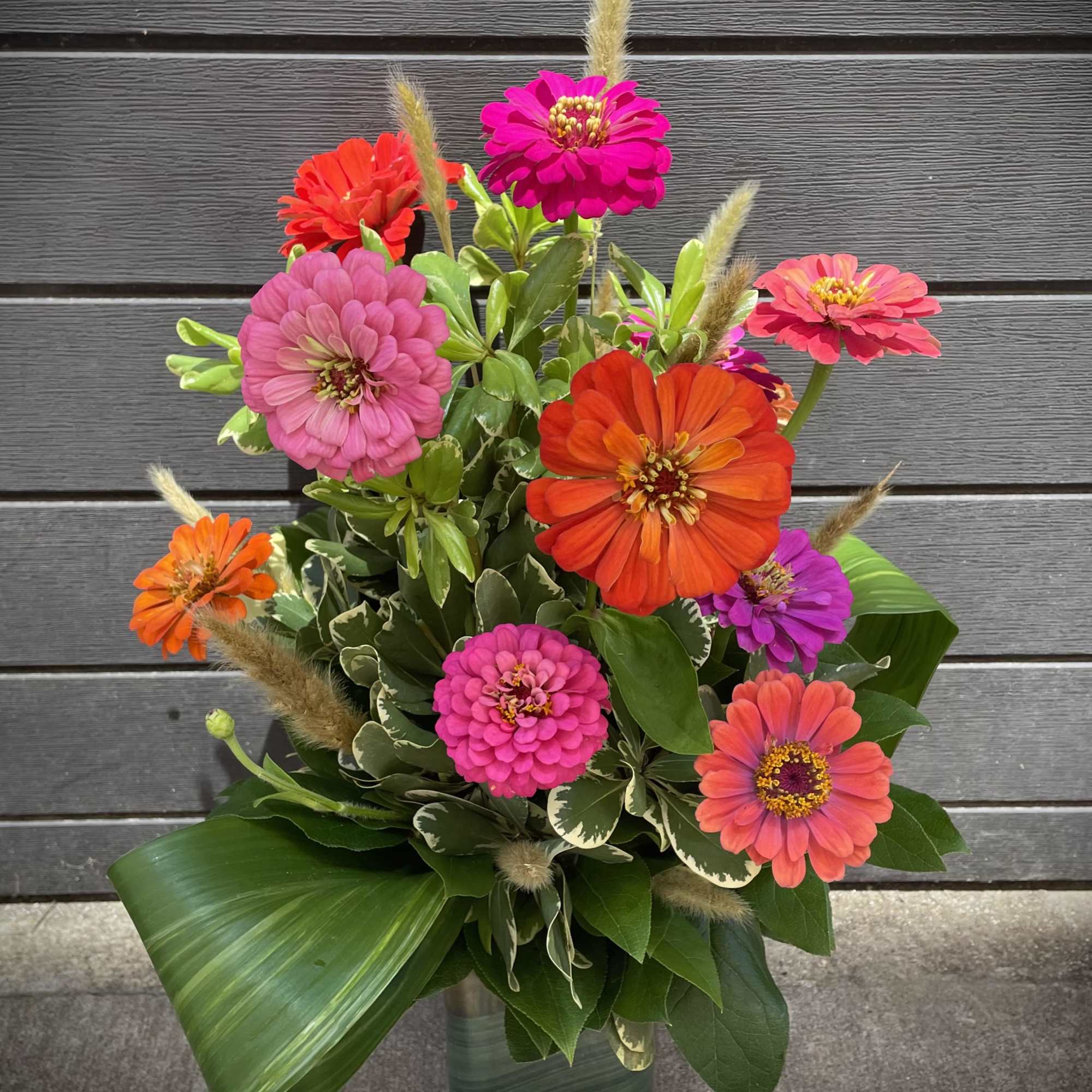 Bright zinnia bouquet in a glass vase with mixed pink, orange, and purple blooms
