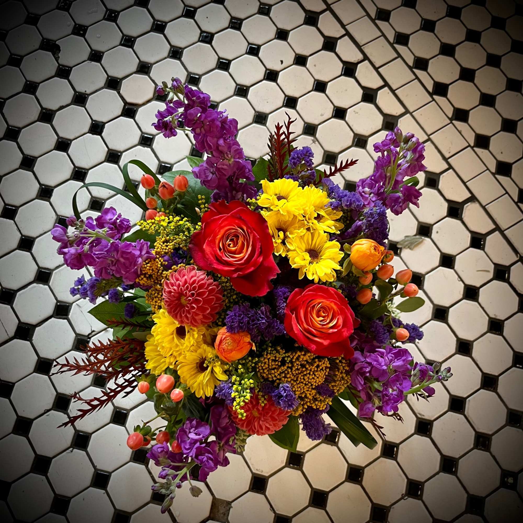 Colorful bouquet with red roses, yellow daisies, and purple flowers