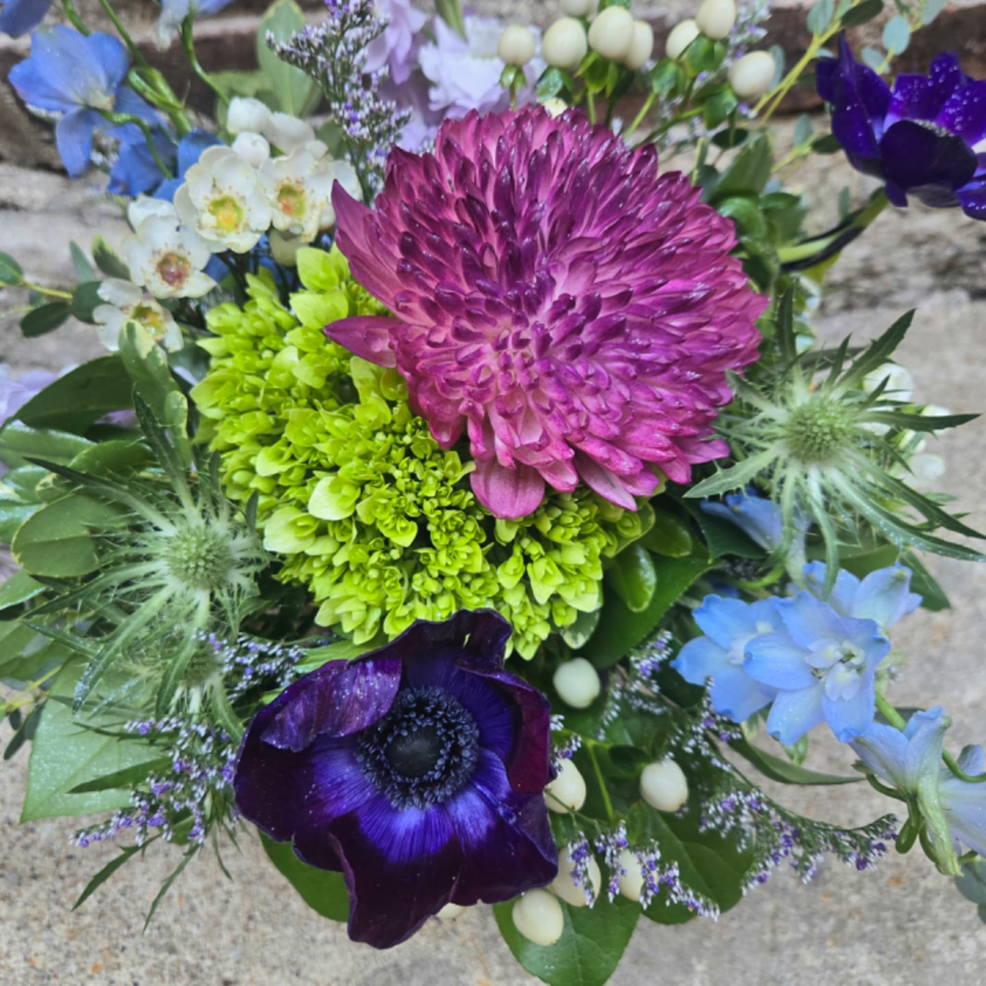 Colorful mixed bouquet with magenta, purple, blue, and green blooms