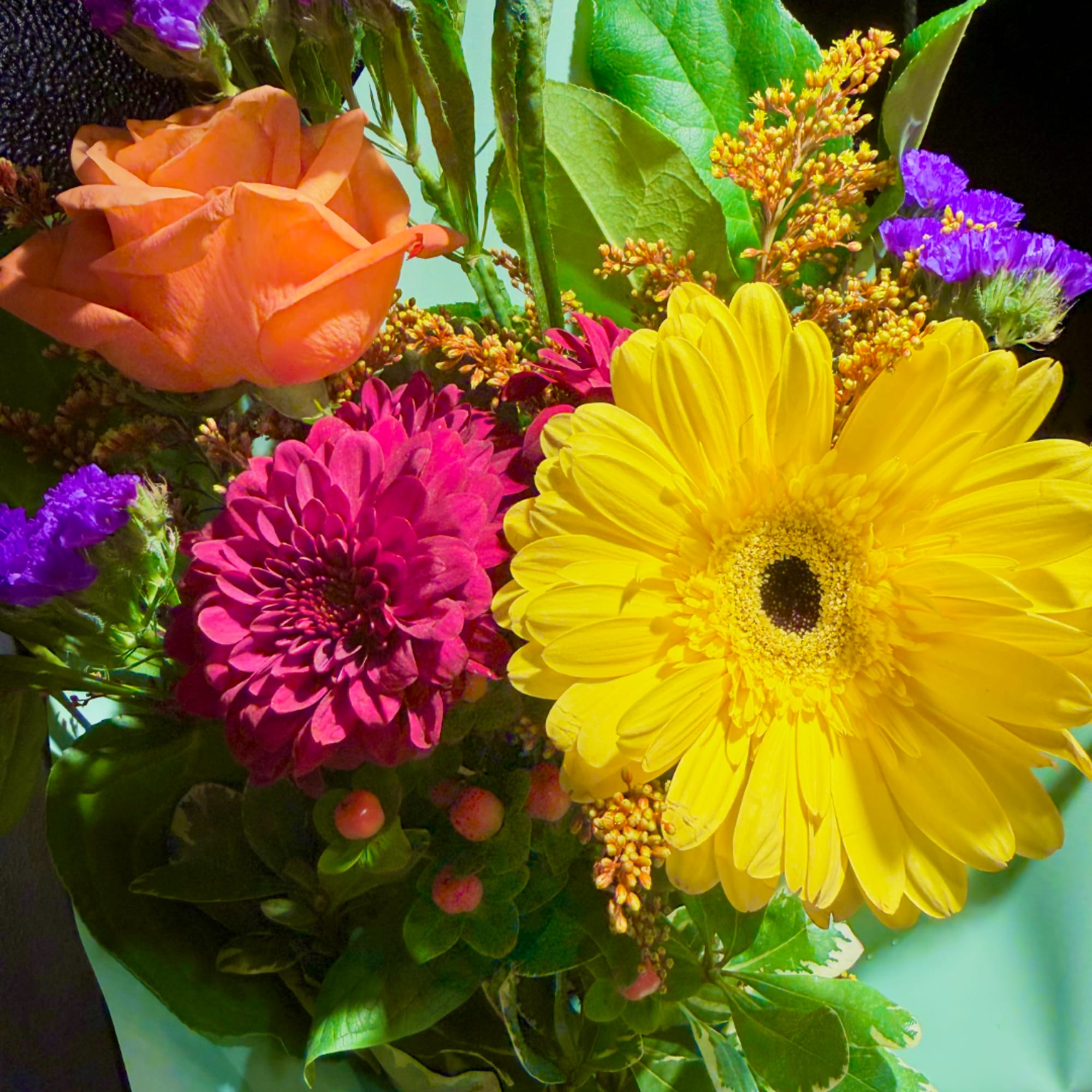 Bright mixed bouquet with a yellow gerbera daisy, pink chrysanthemum, and orange rose