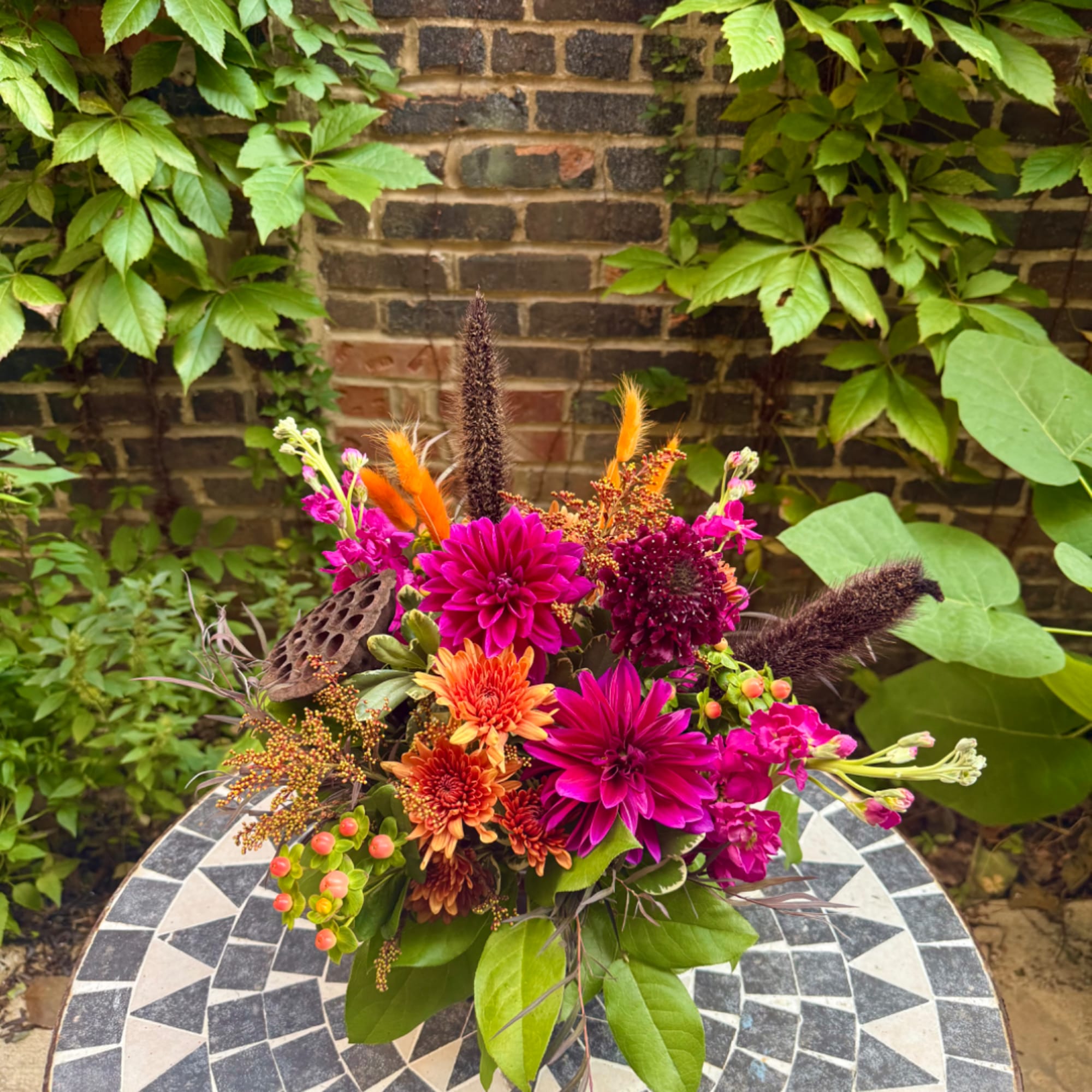 Bright mixed bouquet with magenta and orange flowers in a vase
