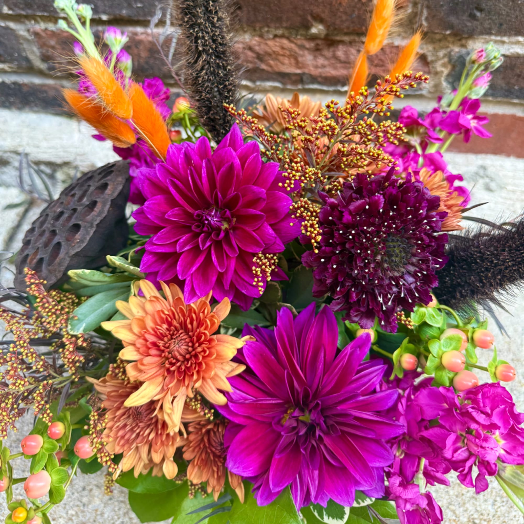 Bright mixed bouquet with magenta and orange flowers and dark accents