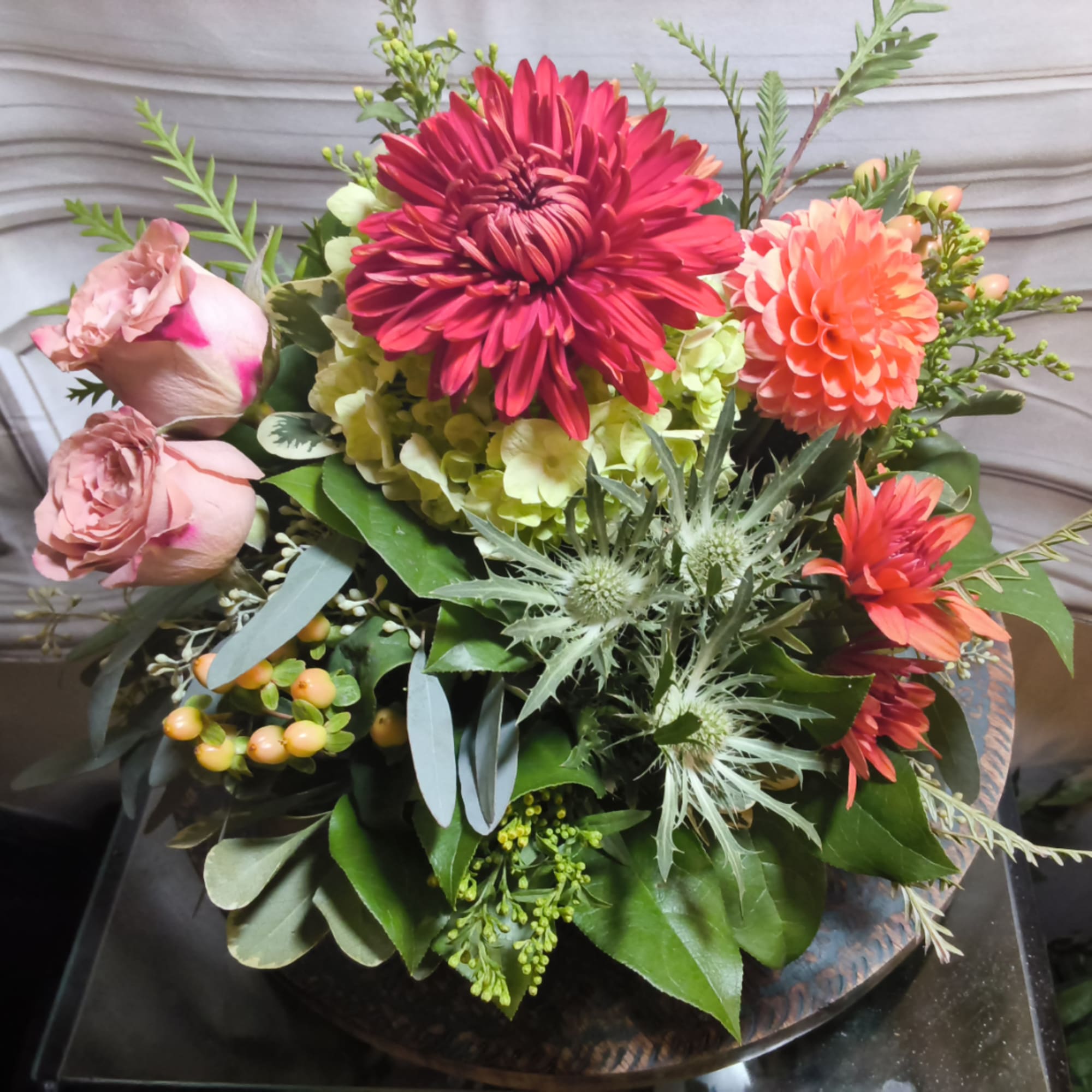 Mixed bouquet with pink roses, dahlias, and hydrangea in a low container