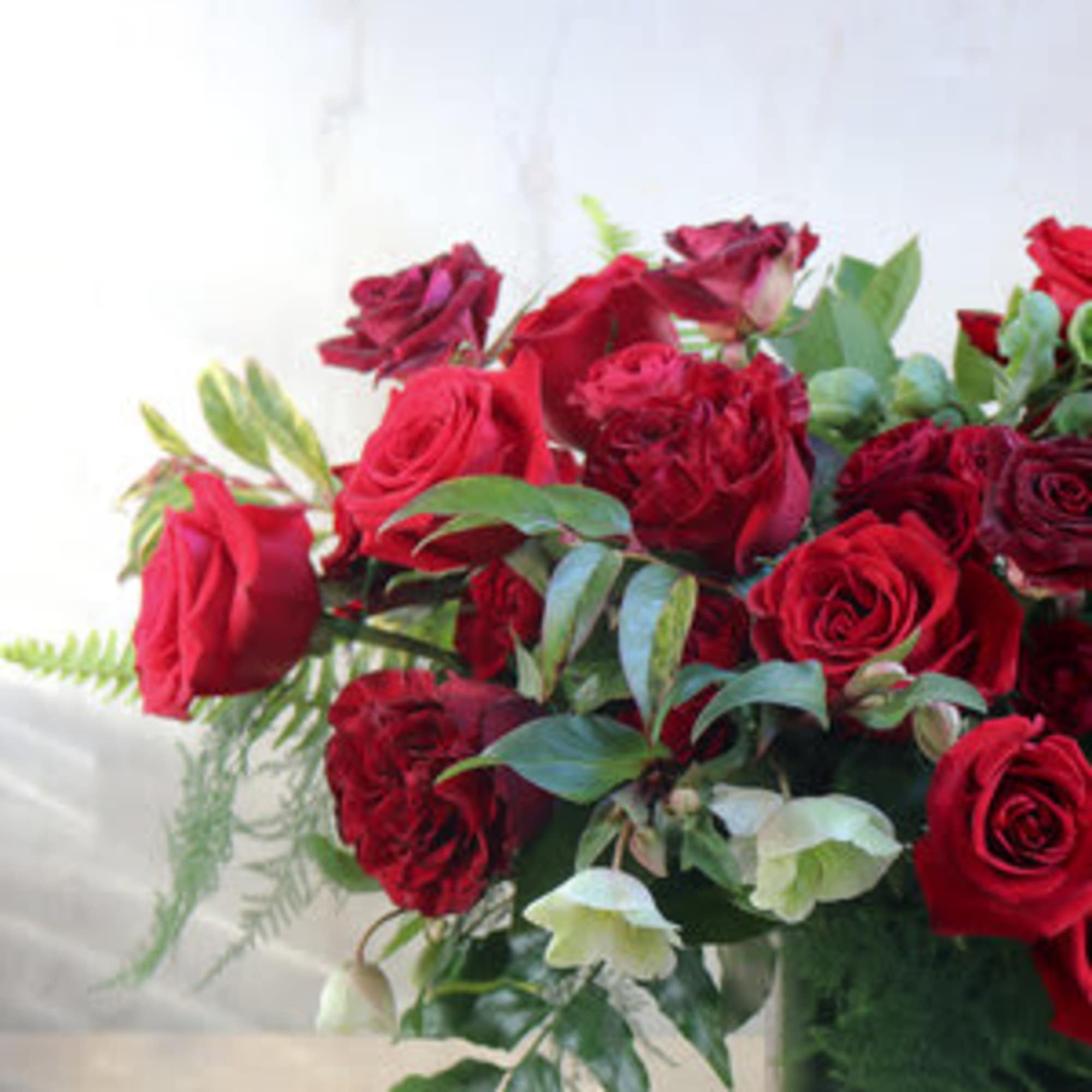 Bouquet of red roses with greenery in a clear vase