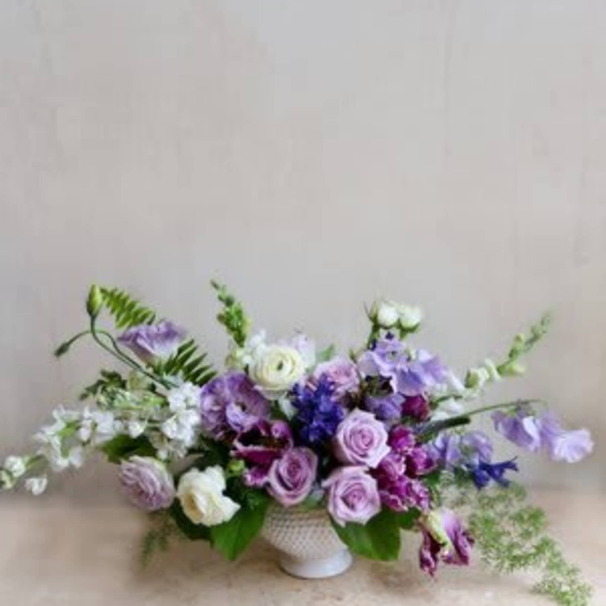 This arrangement with blooms in hues of lavender and plum is a