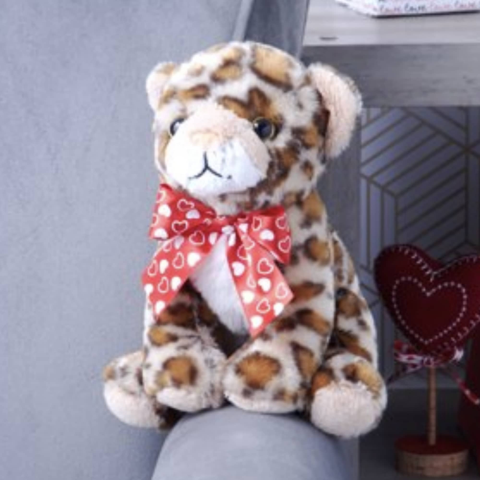Leopard-print plush teddy bear with a red heart-patterned bow