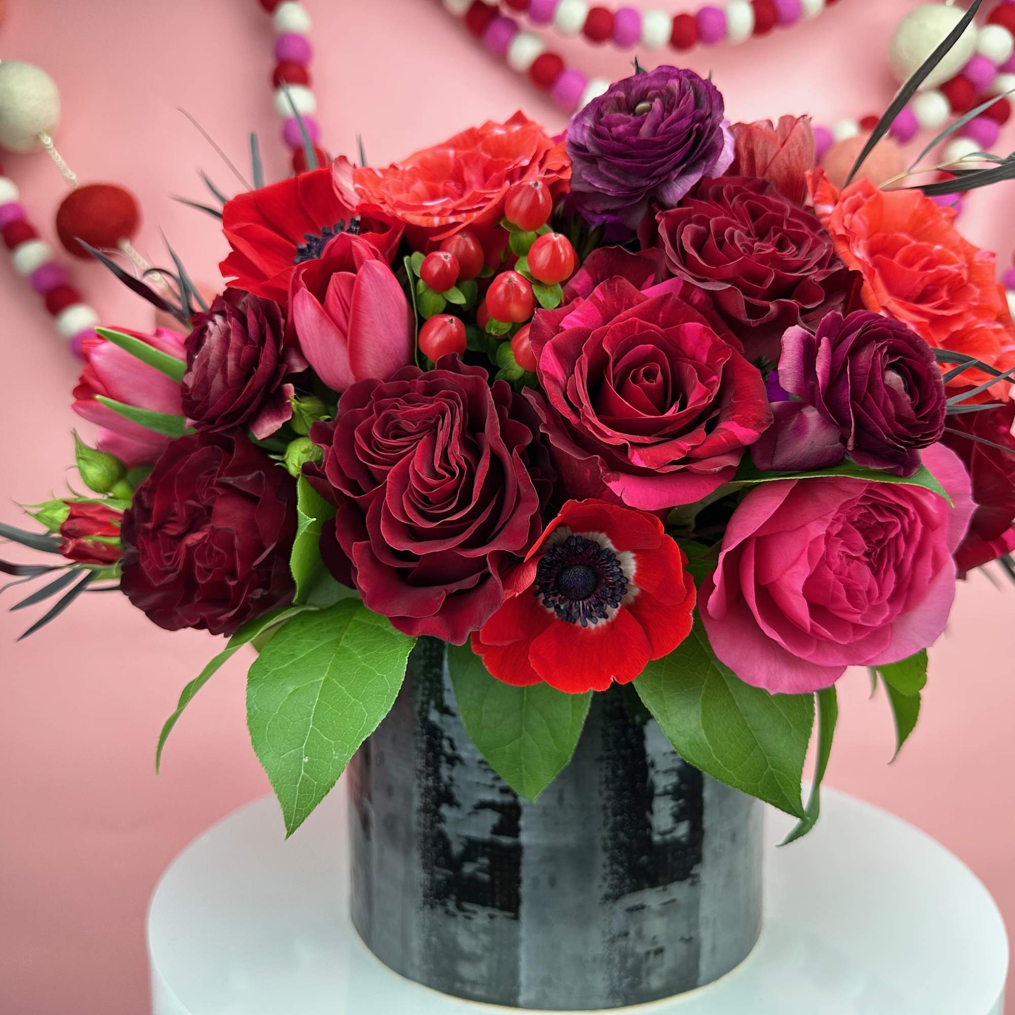 Pink and red rose bouquet in a black vase
