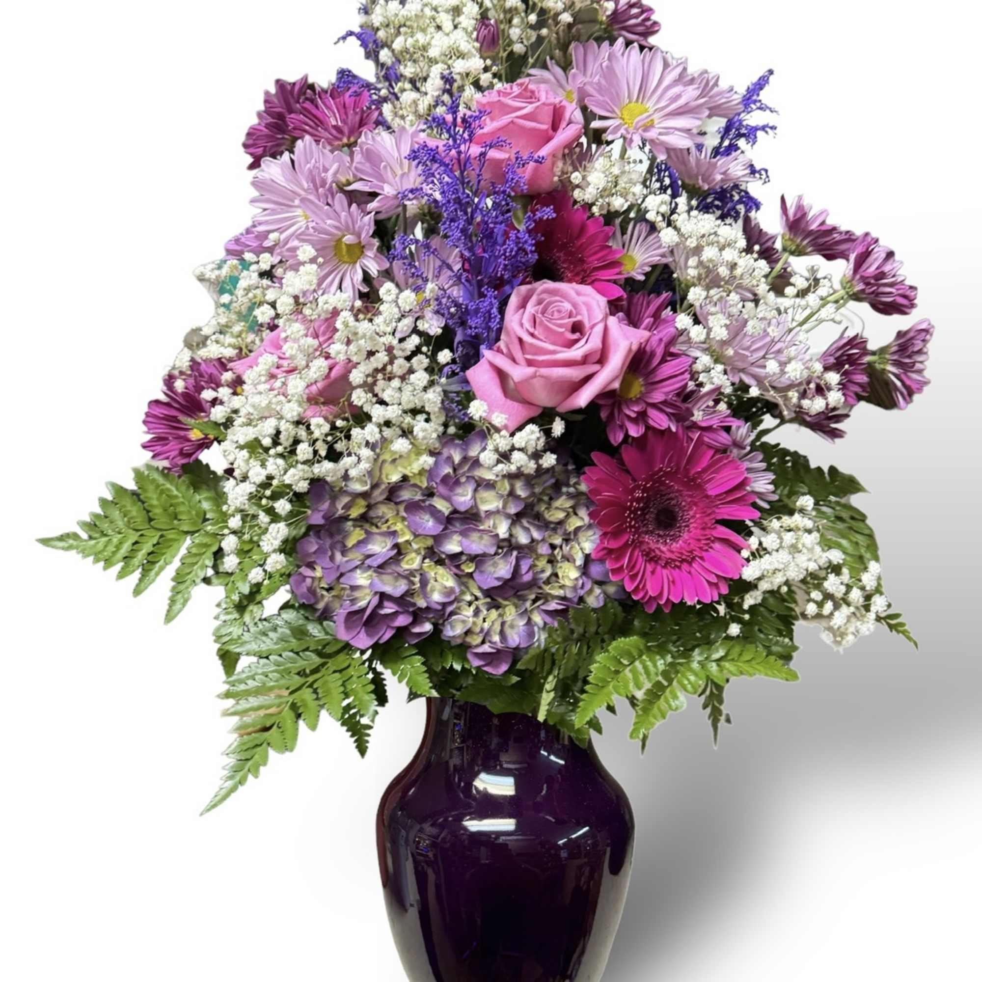 Pink and purple mixed bouquet in a dark glass vase