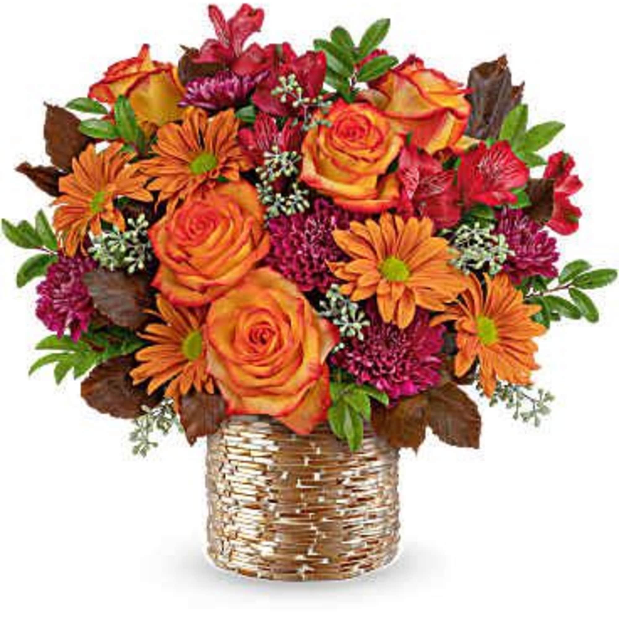 Orange and yellow roses with purple flowers in a woven vase