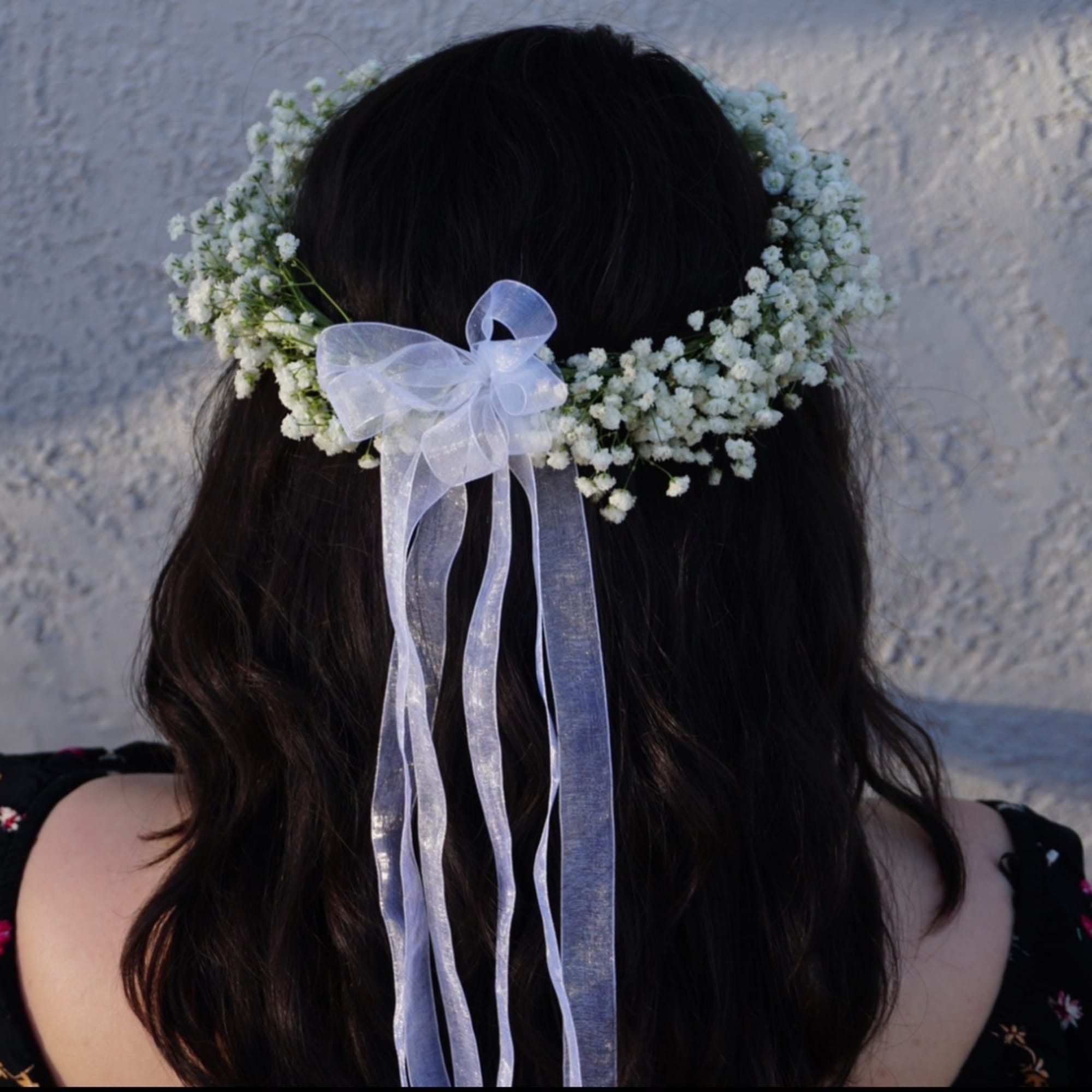 White baby's breath flower crown with a sheer ribbon tied at the back