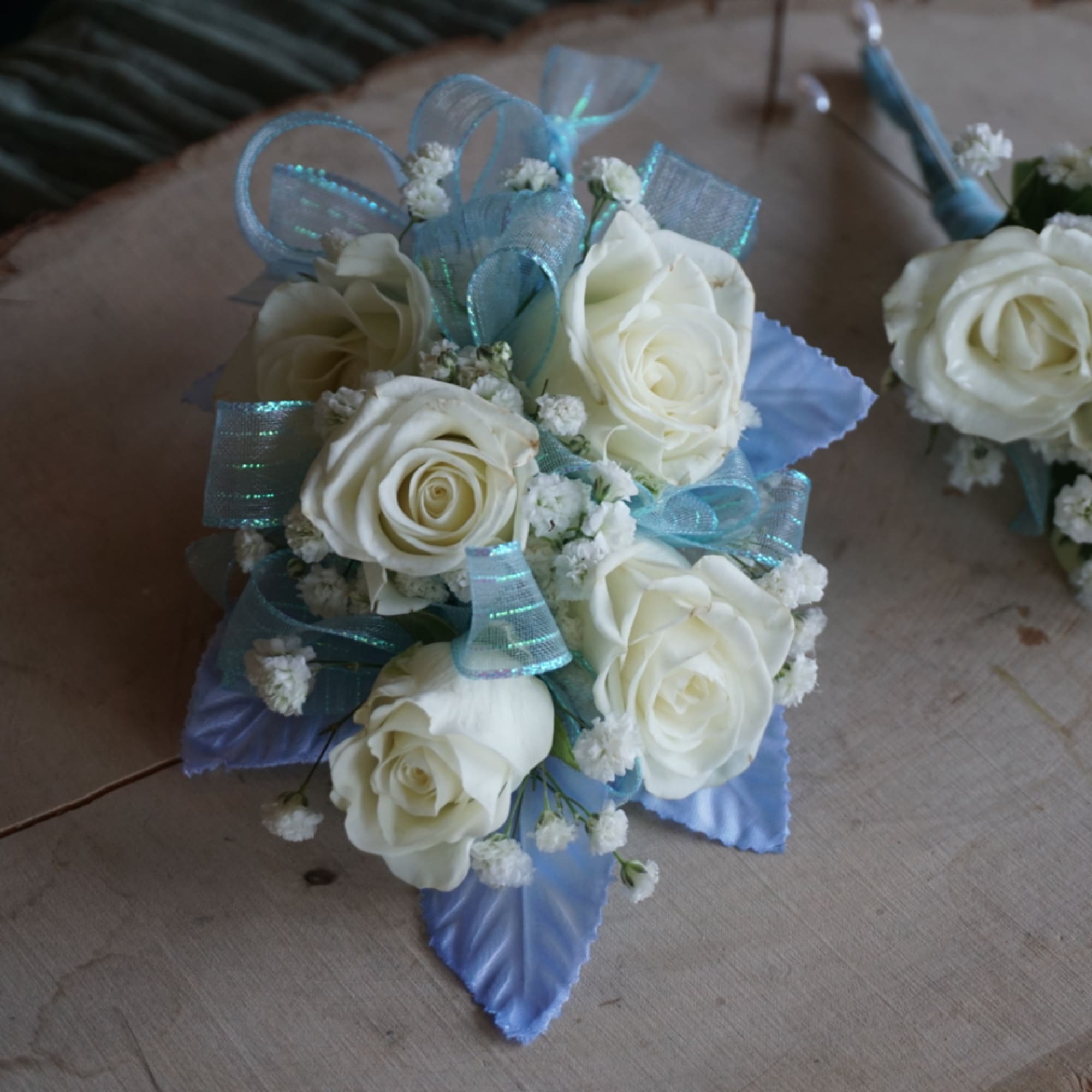White rose wedding bouquet with blue ribbon and small white filler flowers