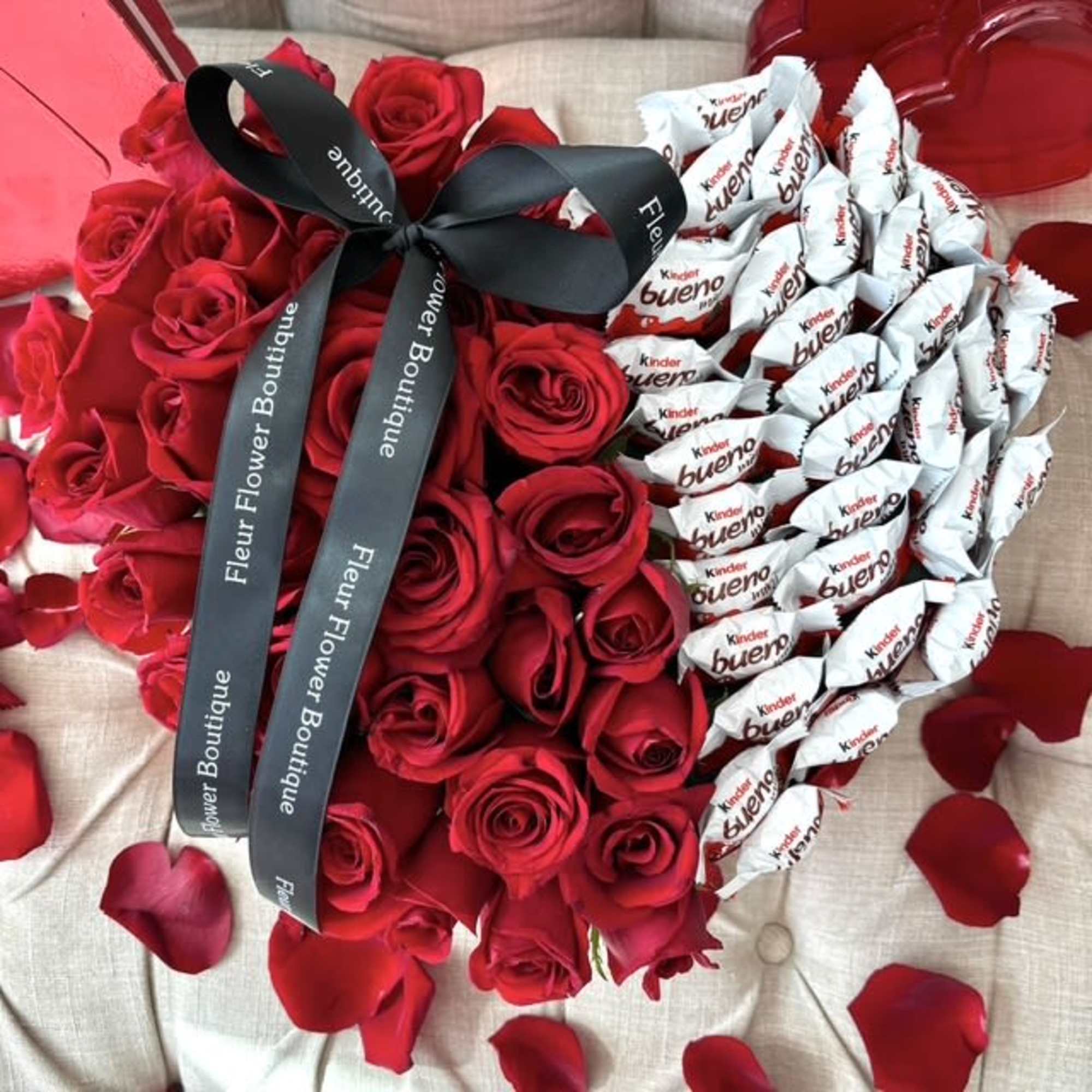 Heart-shaped bouquet of red roses and Kinder Bueno chocolates with a black ribbon