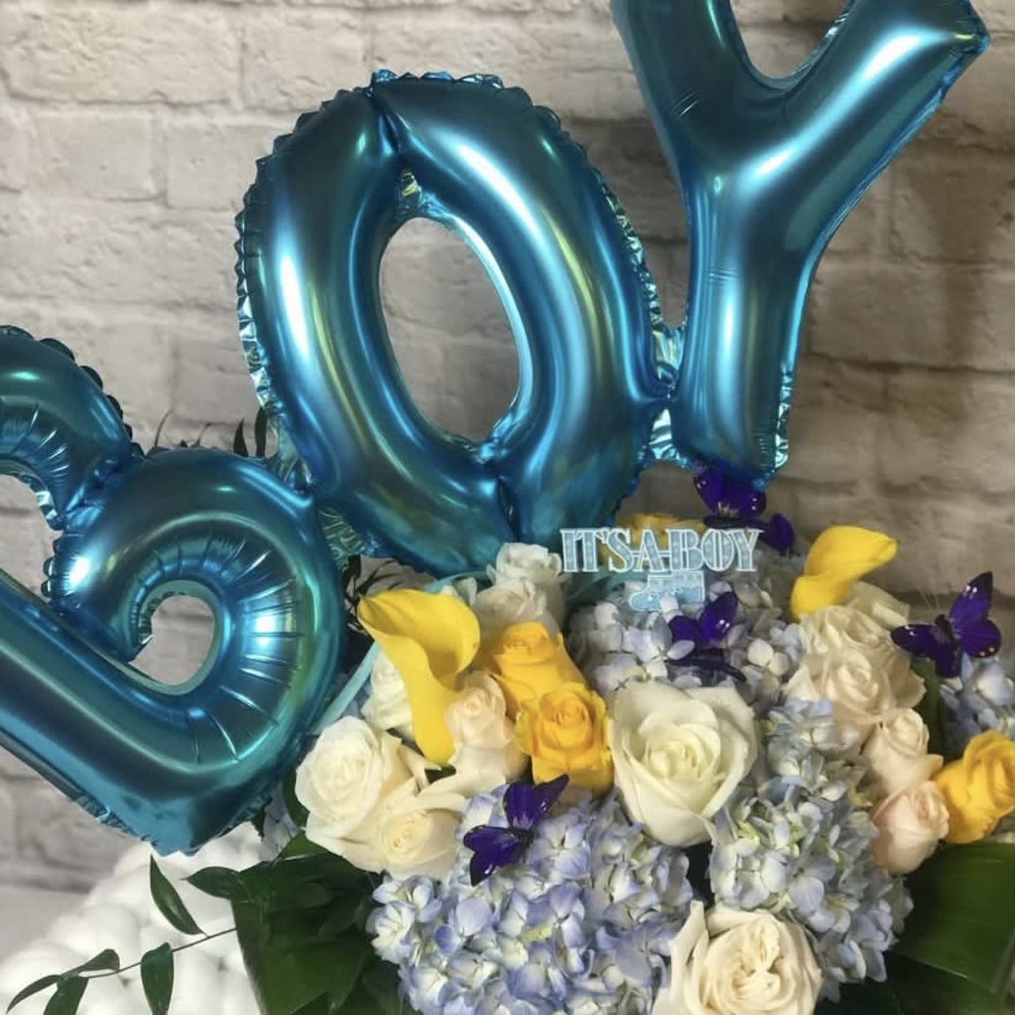 Blue number balloons above a bouquet of roses and hydrangeas