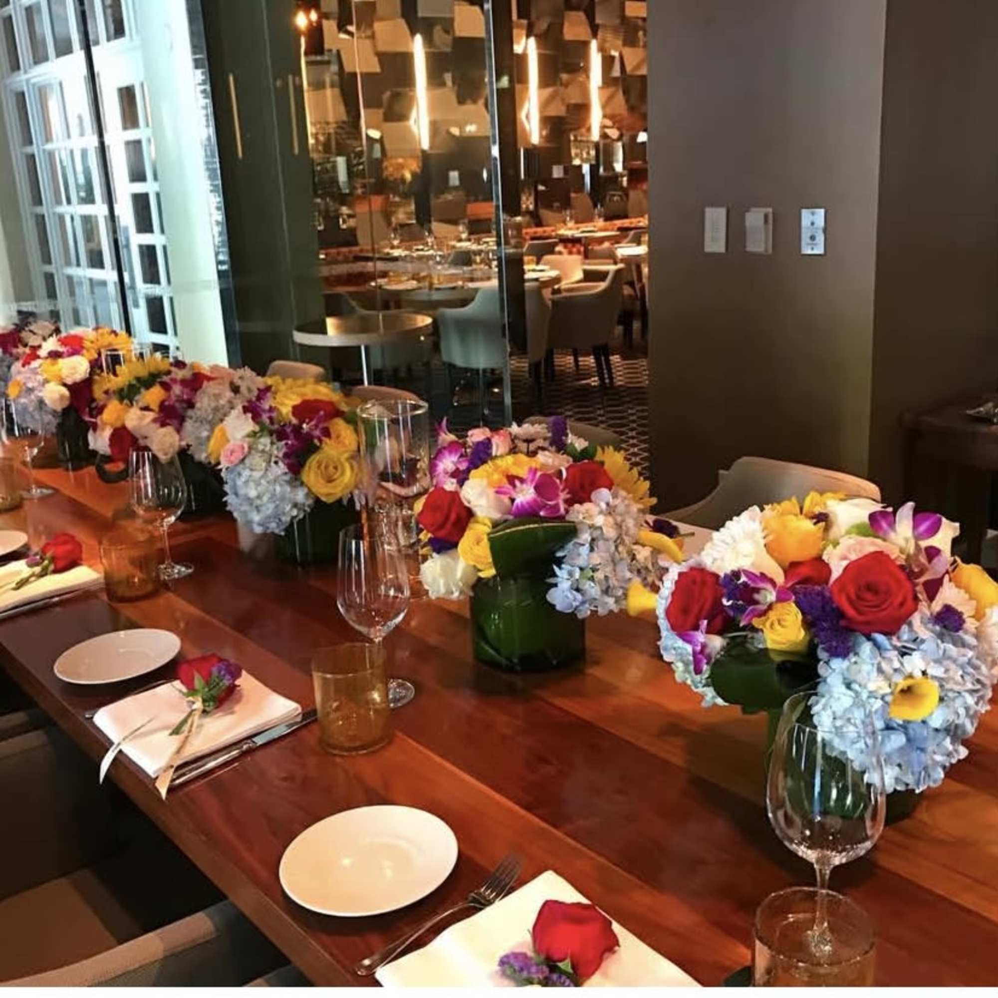 Colorful floral centerpieces arranged along a dining table